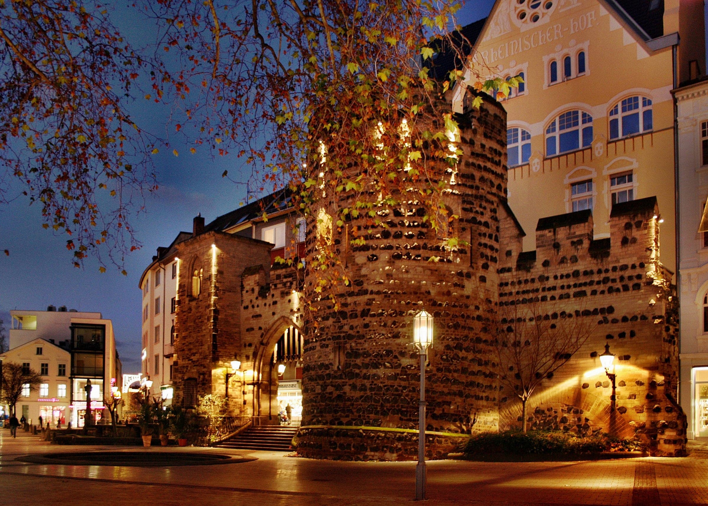 Lamps light the medieval Sterntor gate in Bonn's old town at dusk