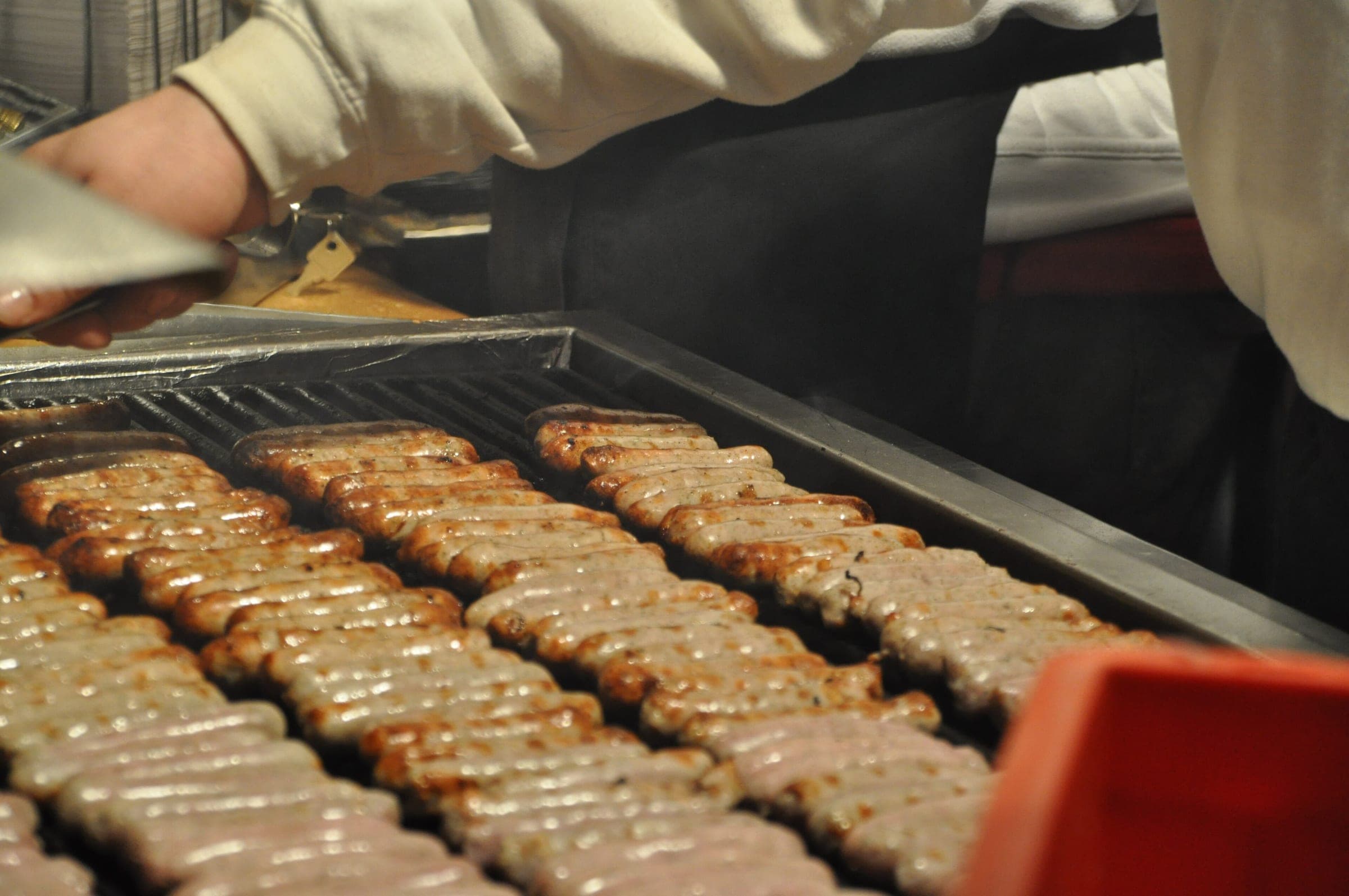 Rows of finger-sized Nürnberger Rostbratwürste sizzle on a grill at a Christkindlesmarkt stall in Nuremberg