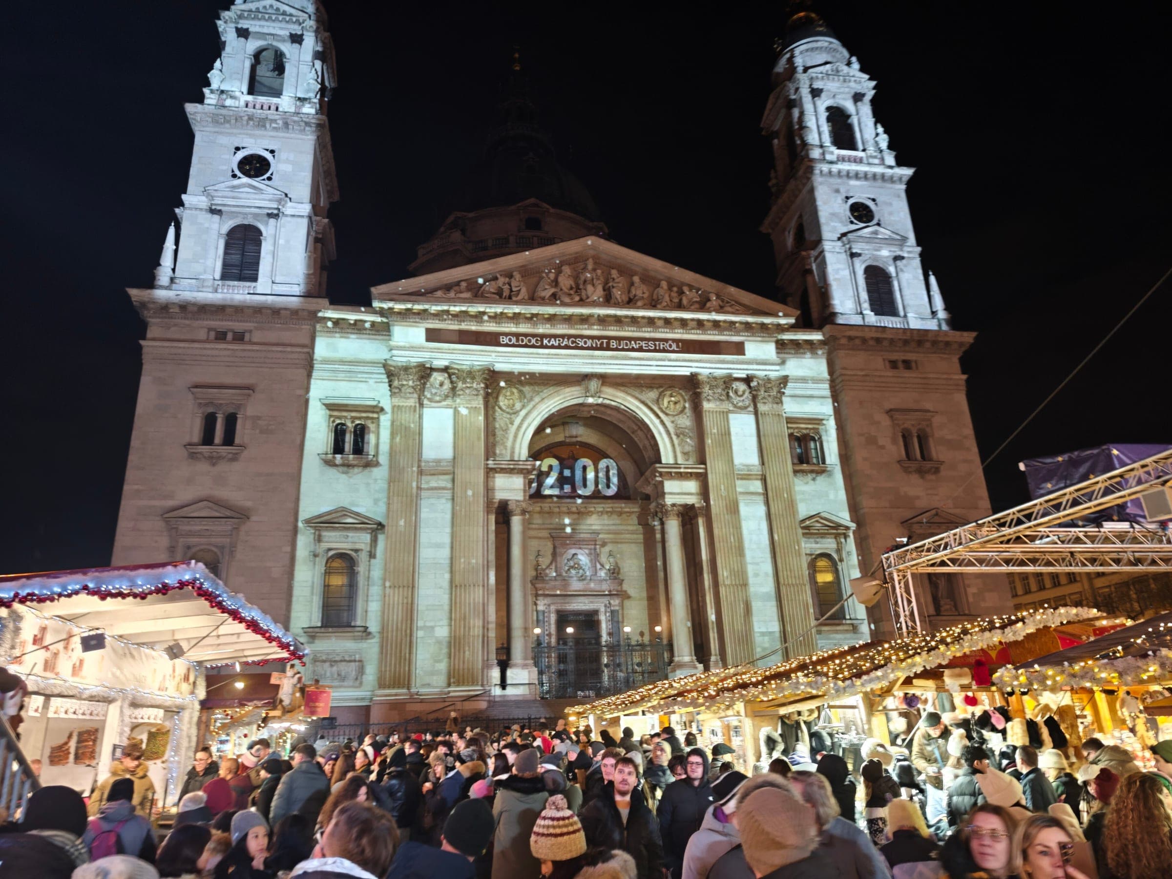 A projected countdown glows on the facade of St. Stephen's Basilica above the crowded Advent market in Budapest.