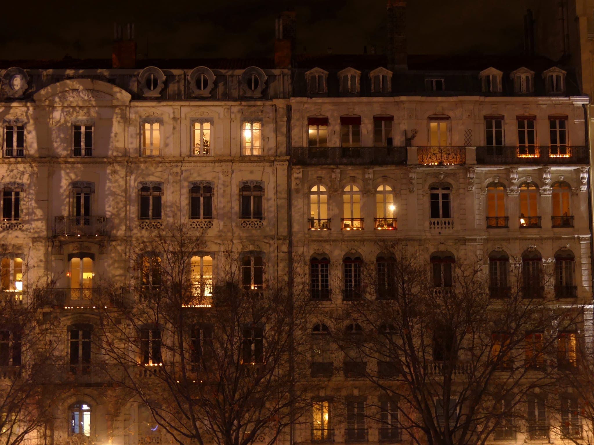 Candles glow in the windows of a Lyon apartment building on the evening of 8 December.