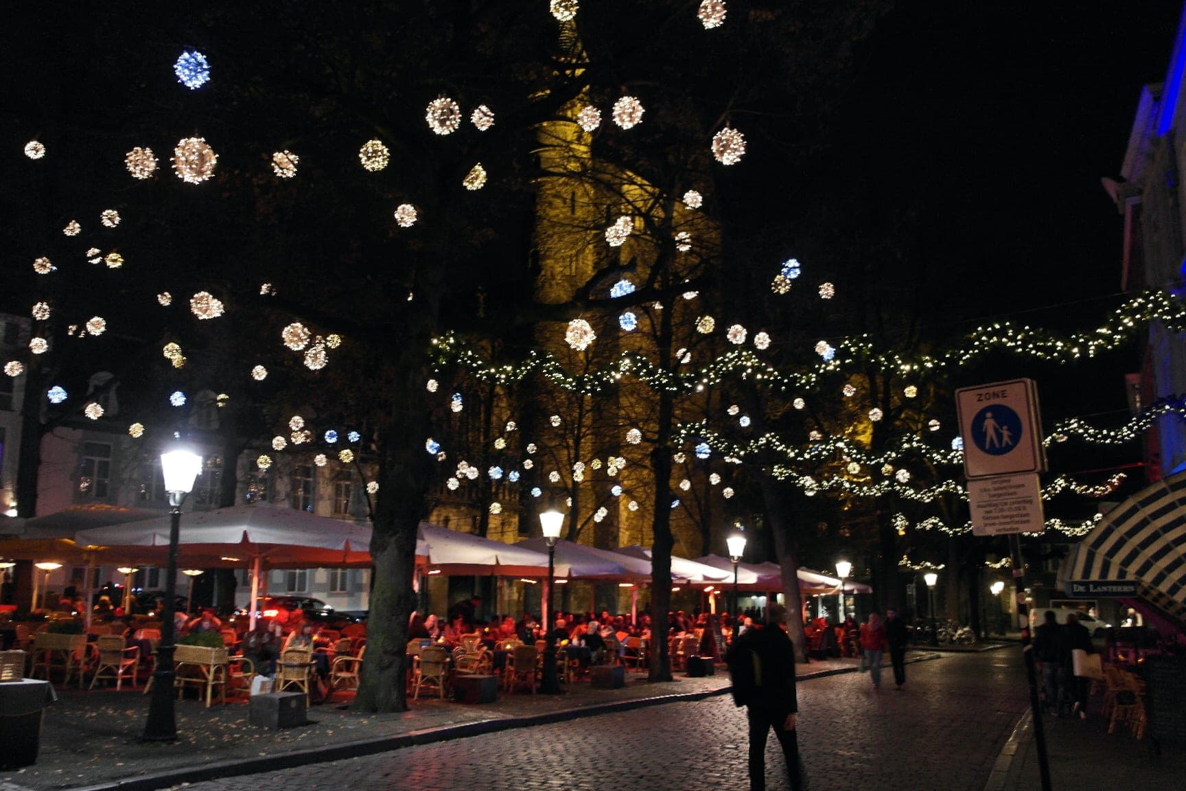 Strings of lights hang through the trees over the café terraces of Onze Lieve Vrouweplein in Maastricht.