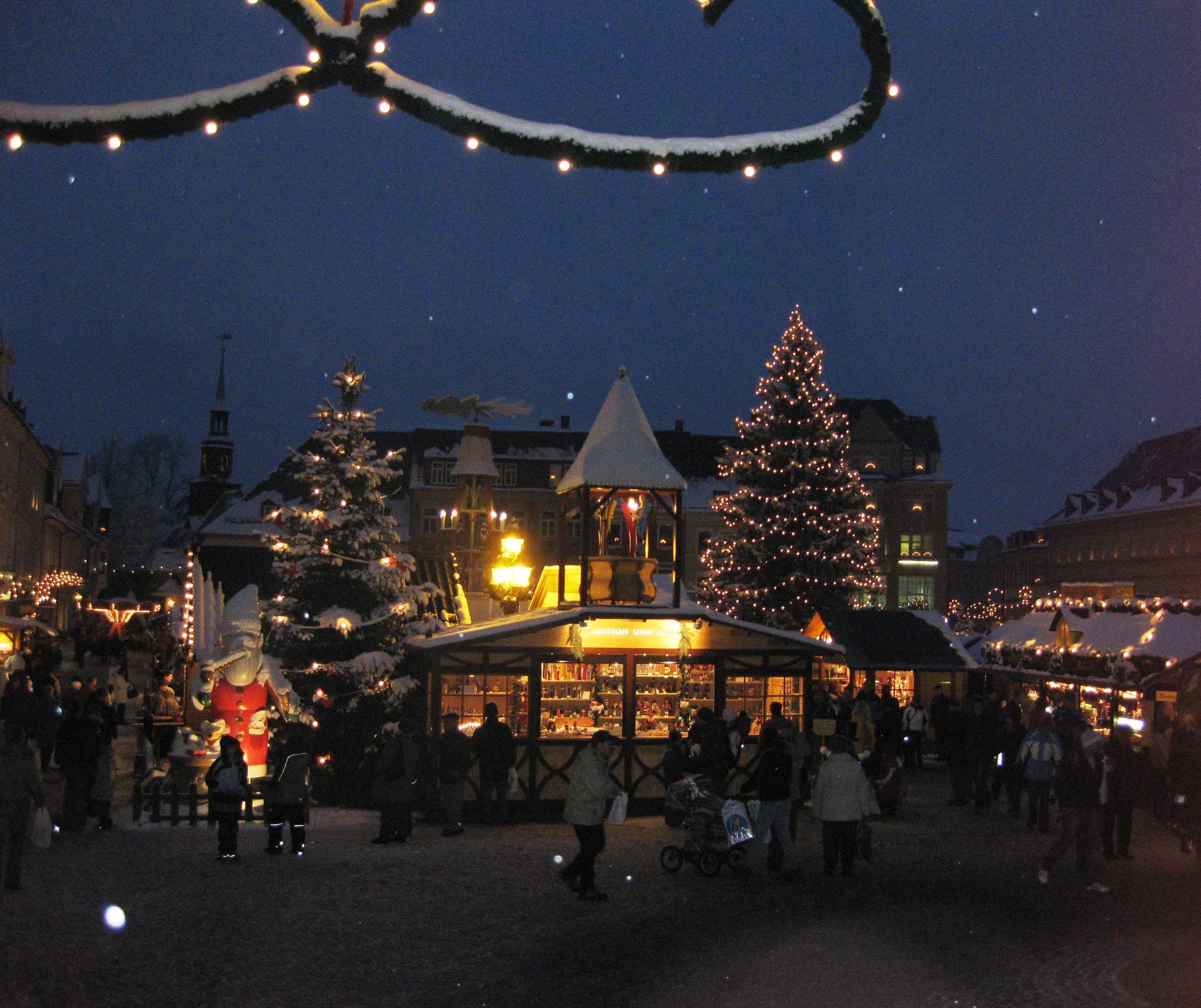 Lit Christmas trees and a turreted pavilion glow over the Annaberg-Buchholz Christmas market at night.