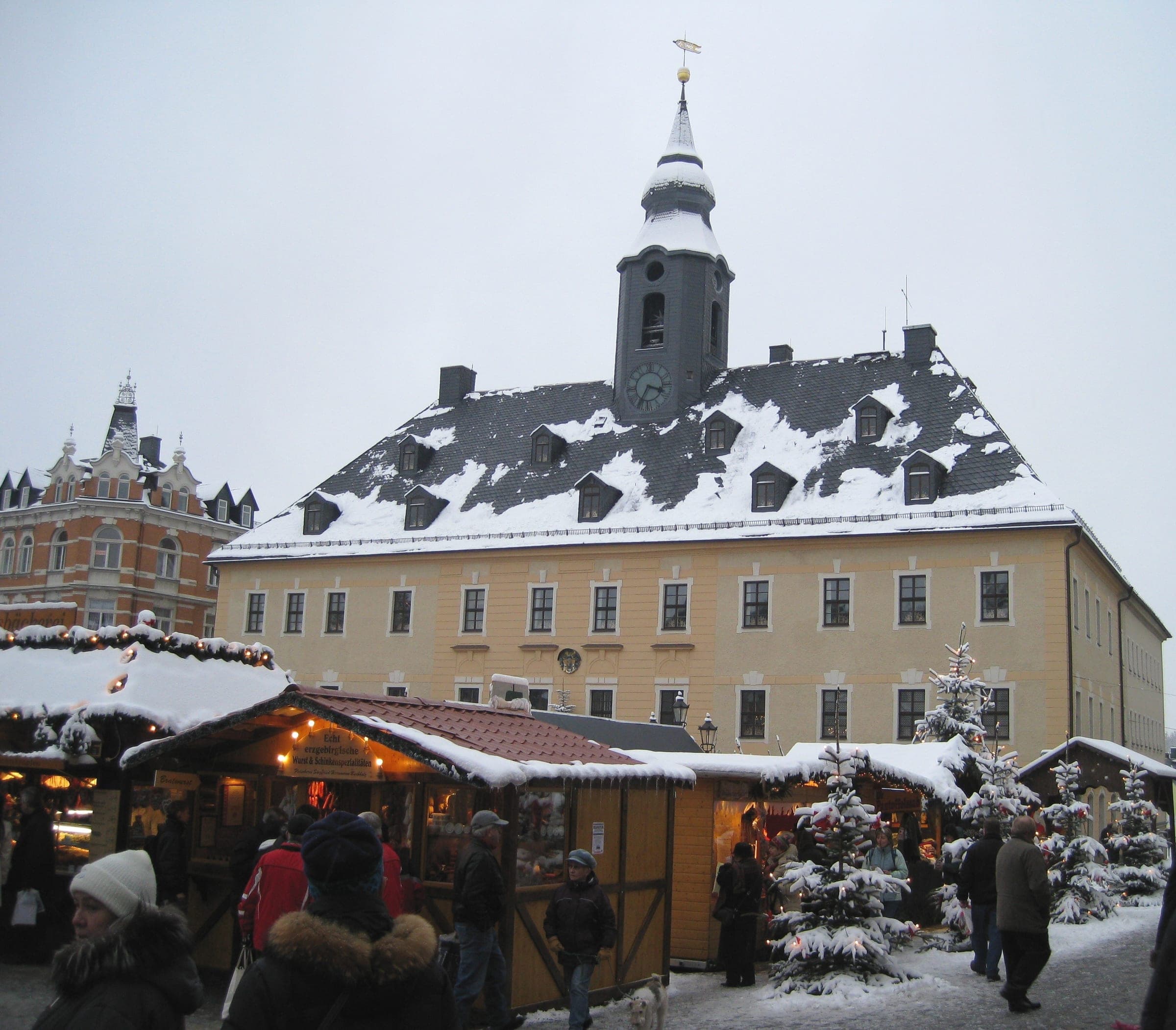 Snow-covered stalls stand in front of the town hall of Annaberg-Buchholz during the Christmas market.