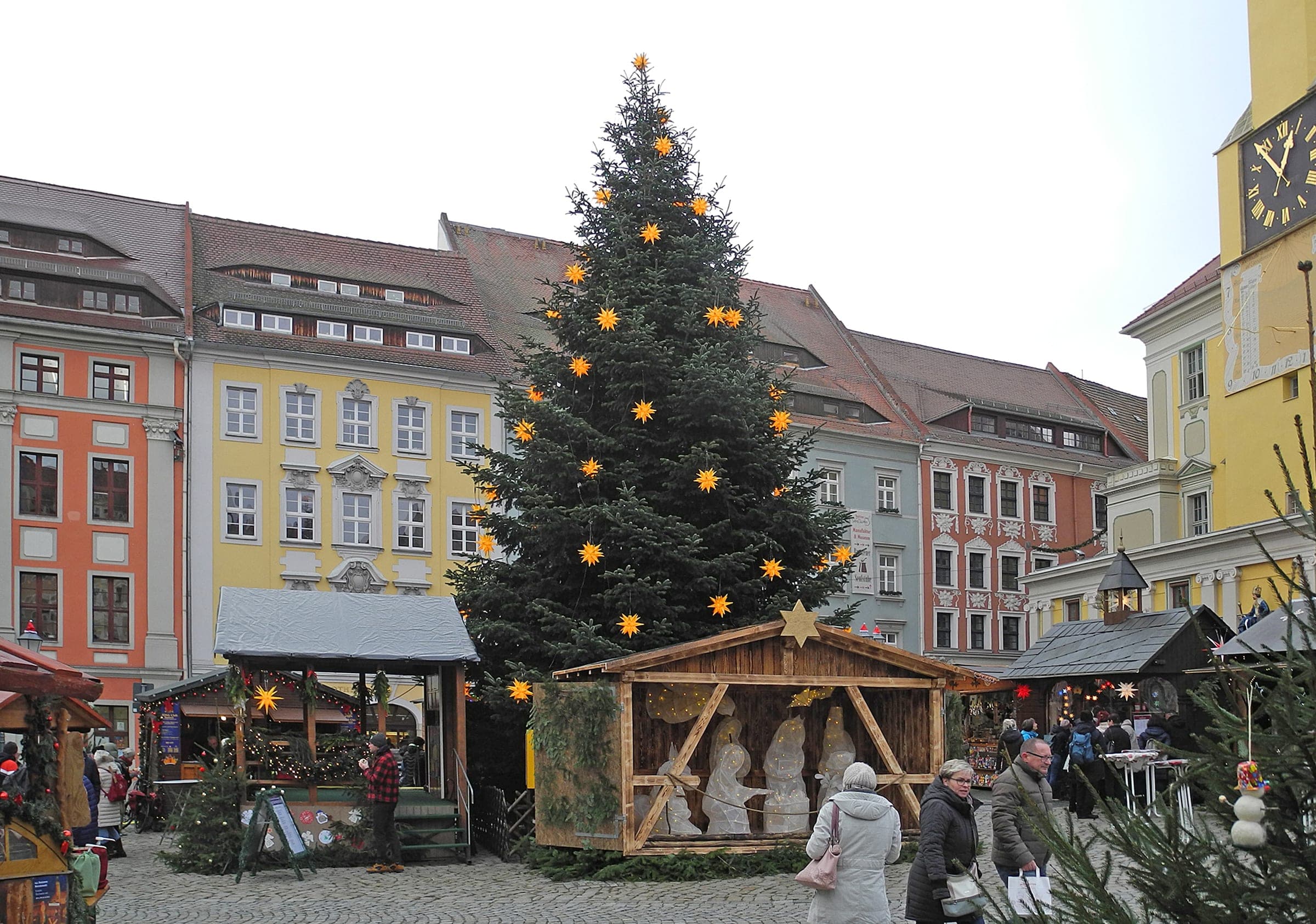 A starred Christmas tree and a carved nativity stand among the Wenzelsmarkt stalls in Bautzen.