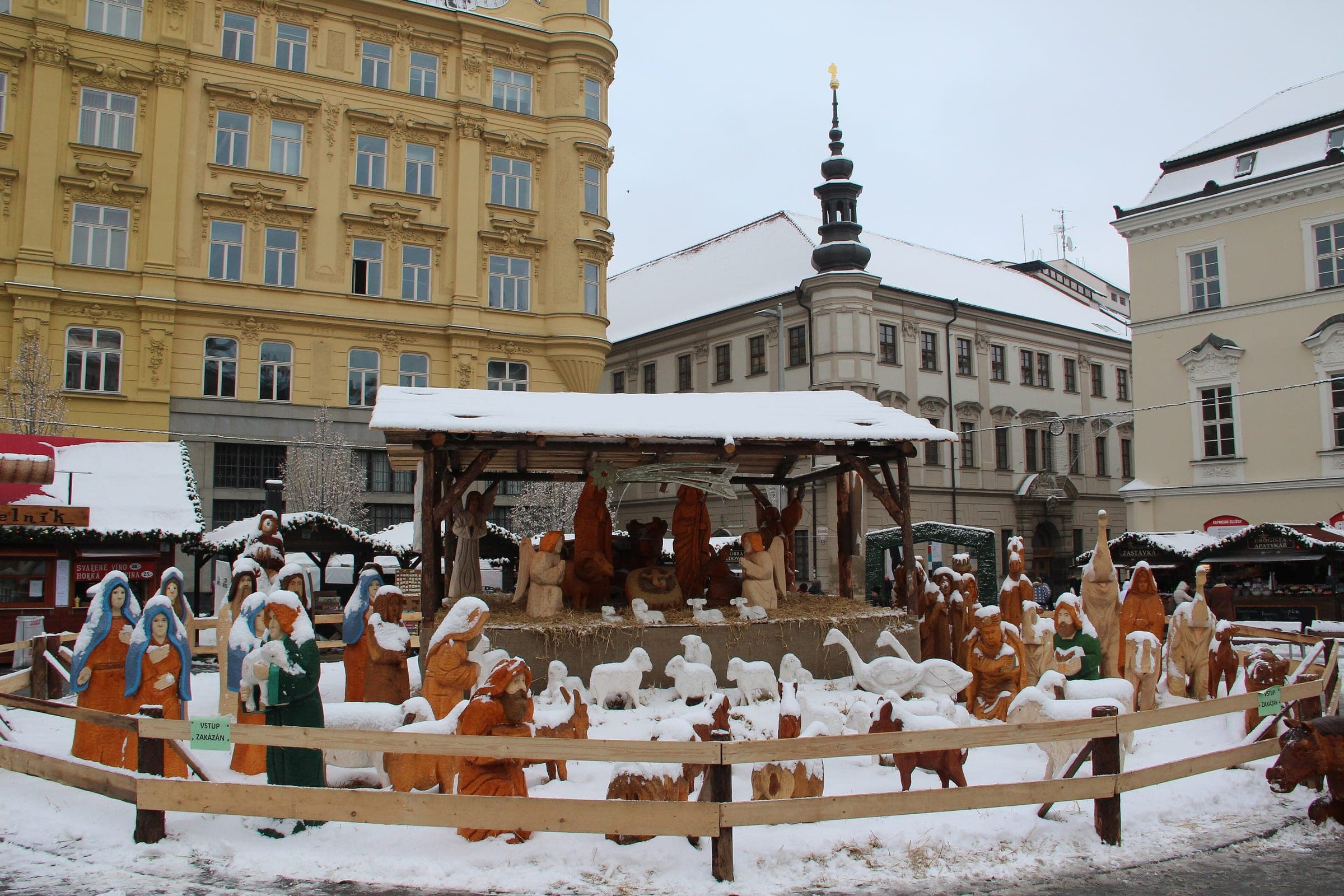 Snow settles on the carved figures of the nativity scene at the Brno Christmas market on náměstí Svobody.