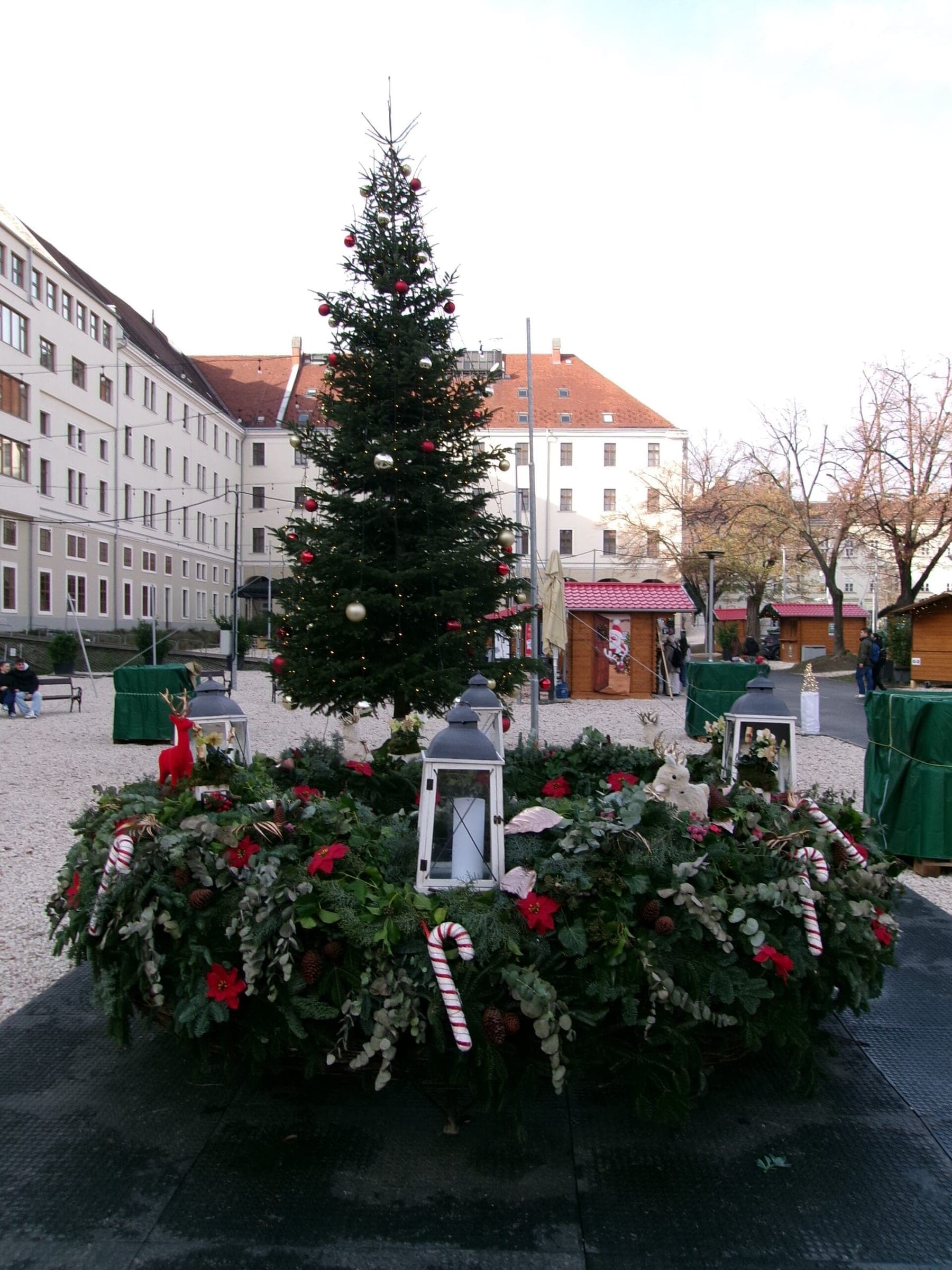 A giant Advent wreath with lanterns and candy canes sits below the Christmas tree in Városháza Park, Budapest.
