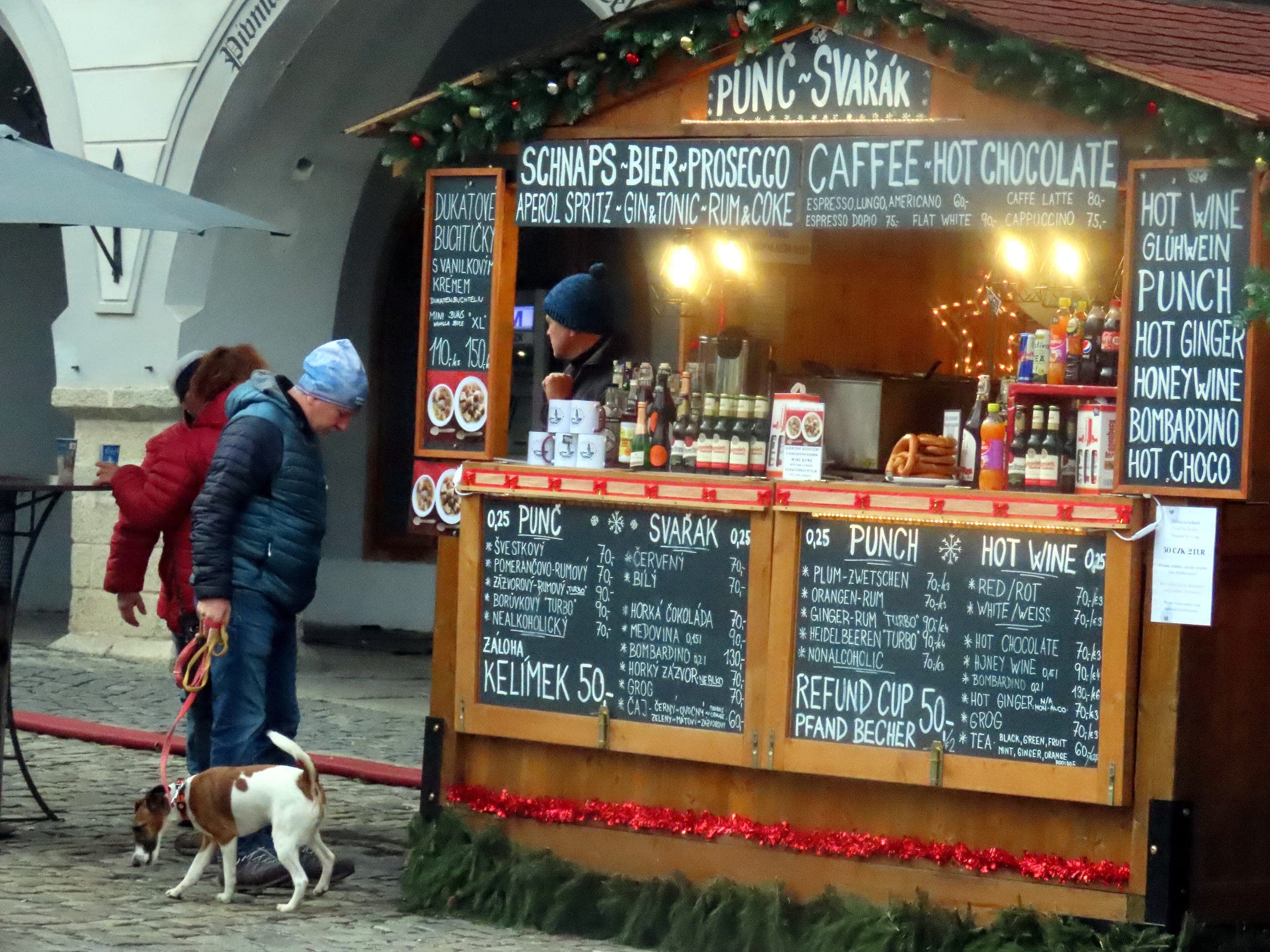 A wooden stall on náměstí Svornosti in Český Krumlov chalks up its prices for svařák and hot punch.