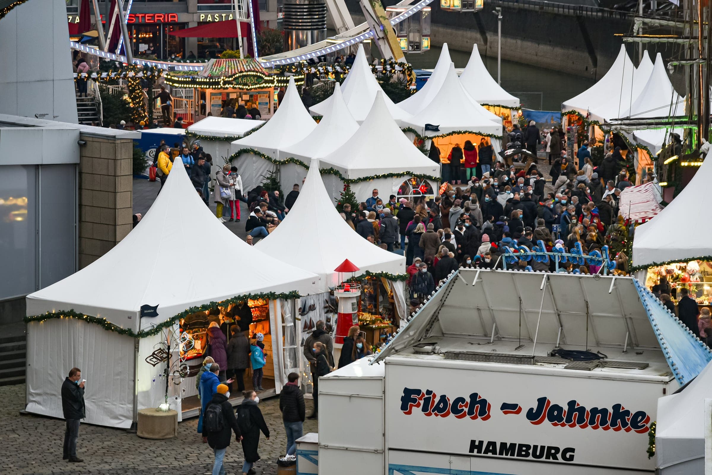 White tents of the harbour Christmas market crowd the quay at Cologne's Chocolate Museum