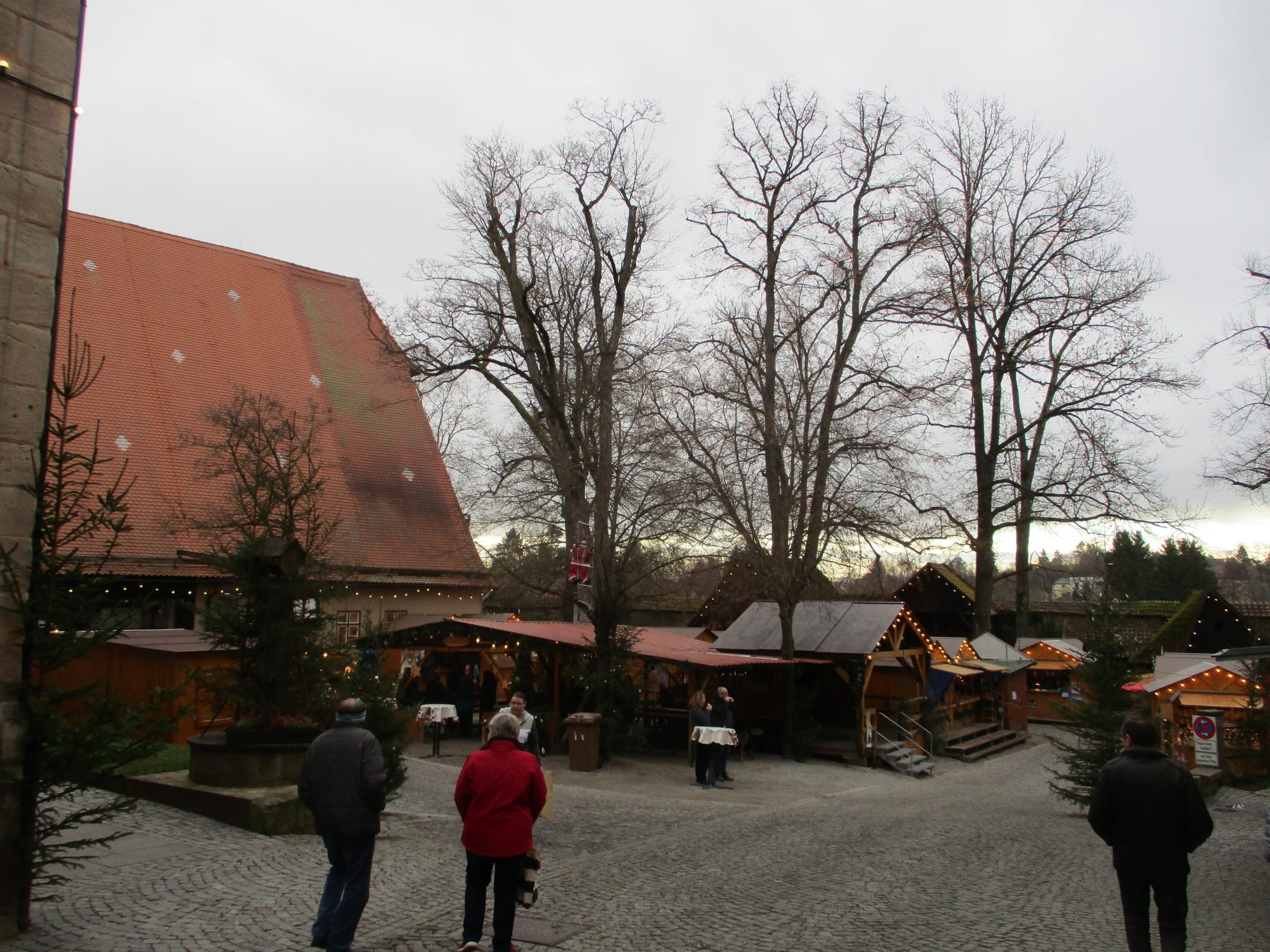 Wooden stalls line the Spitalhof under bare trees at the Dinkelsbühl Christmas market