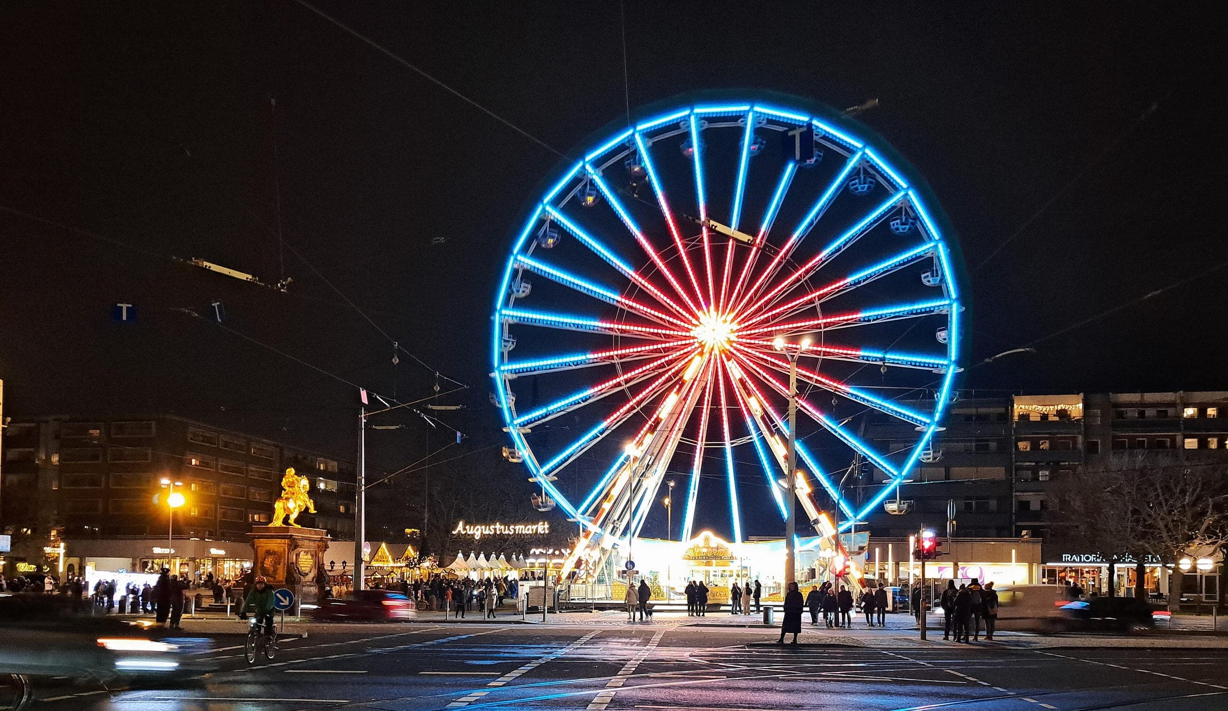 The Augustusmarkt Ferris wheel glows beside the Golden Rider statue at the head of Dresden's Hauptstraße.