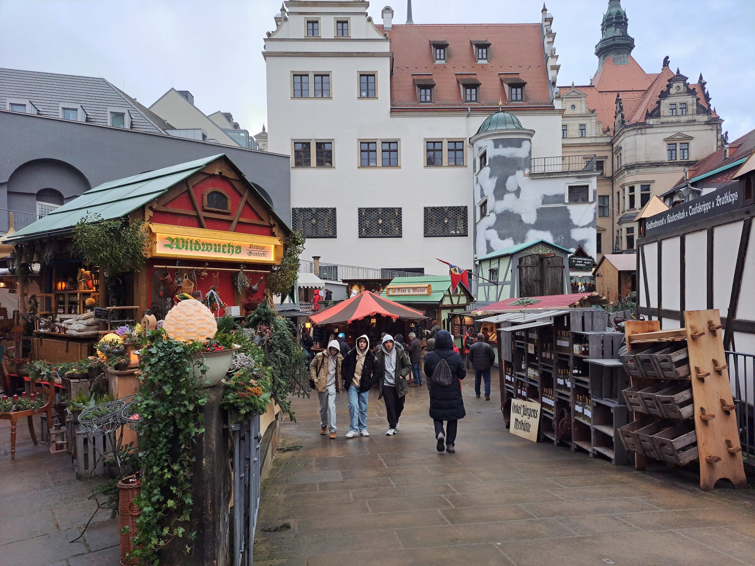 Wooden stalls of the medieval Christmas market stand in the Stallhof courtyard in Dresden by day.
