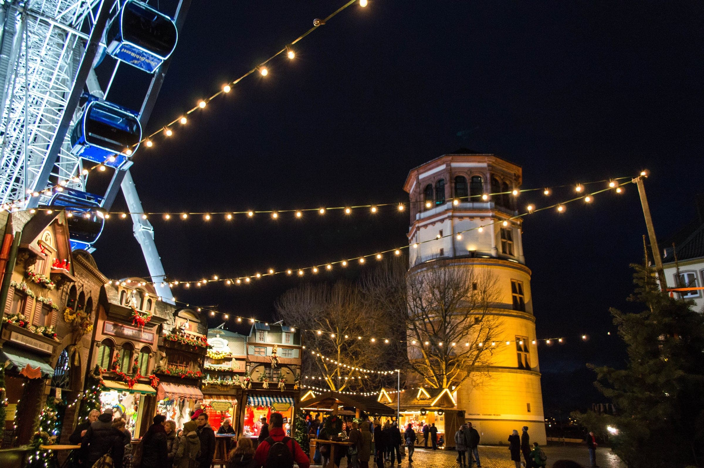 Strings of lights run from the big wheel to the Schlossturm over the Burgplatz market in Düsseldorf