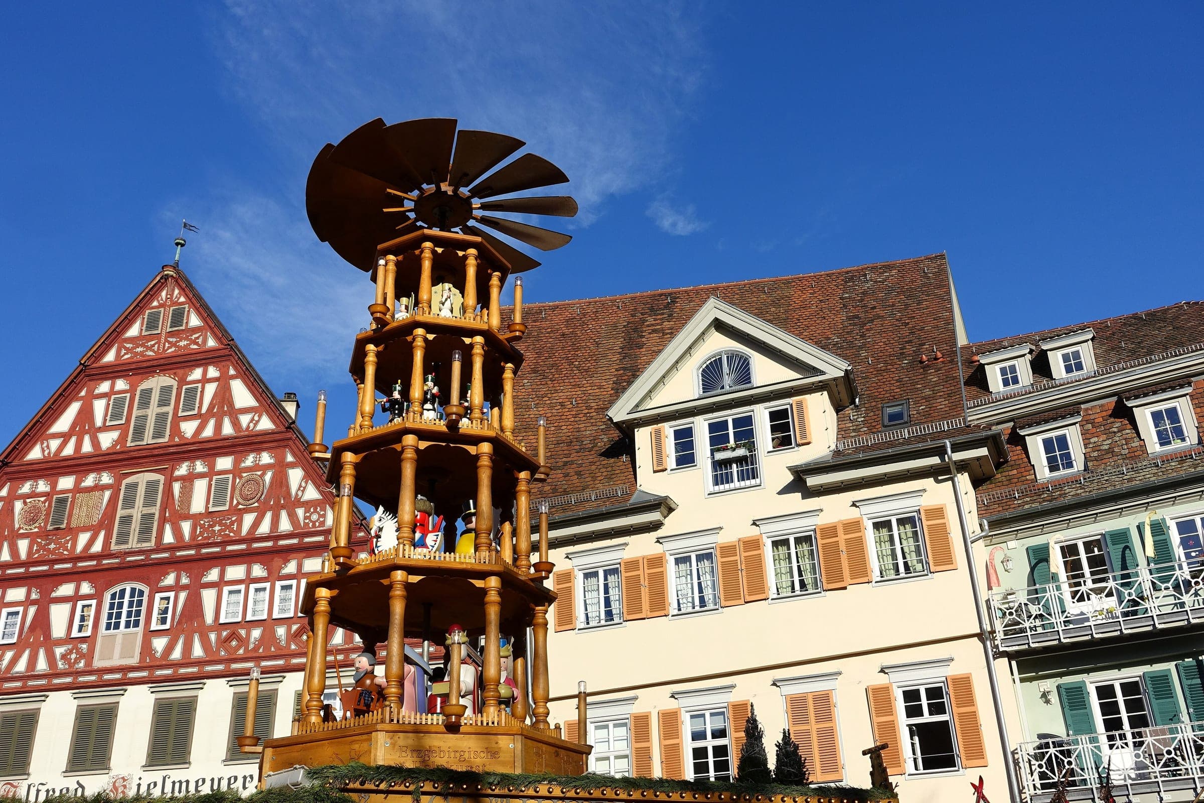 A tall wooden Christmas pyramid stands before timber-framed houses on the Marktplatz in Esslingen.