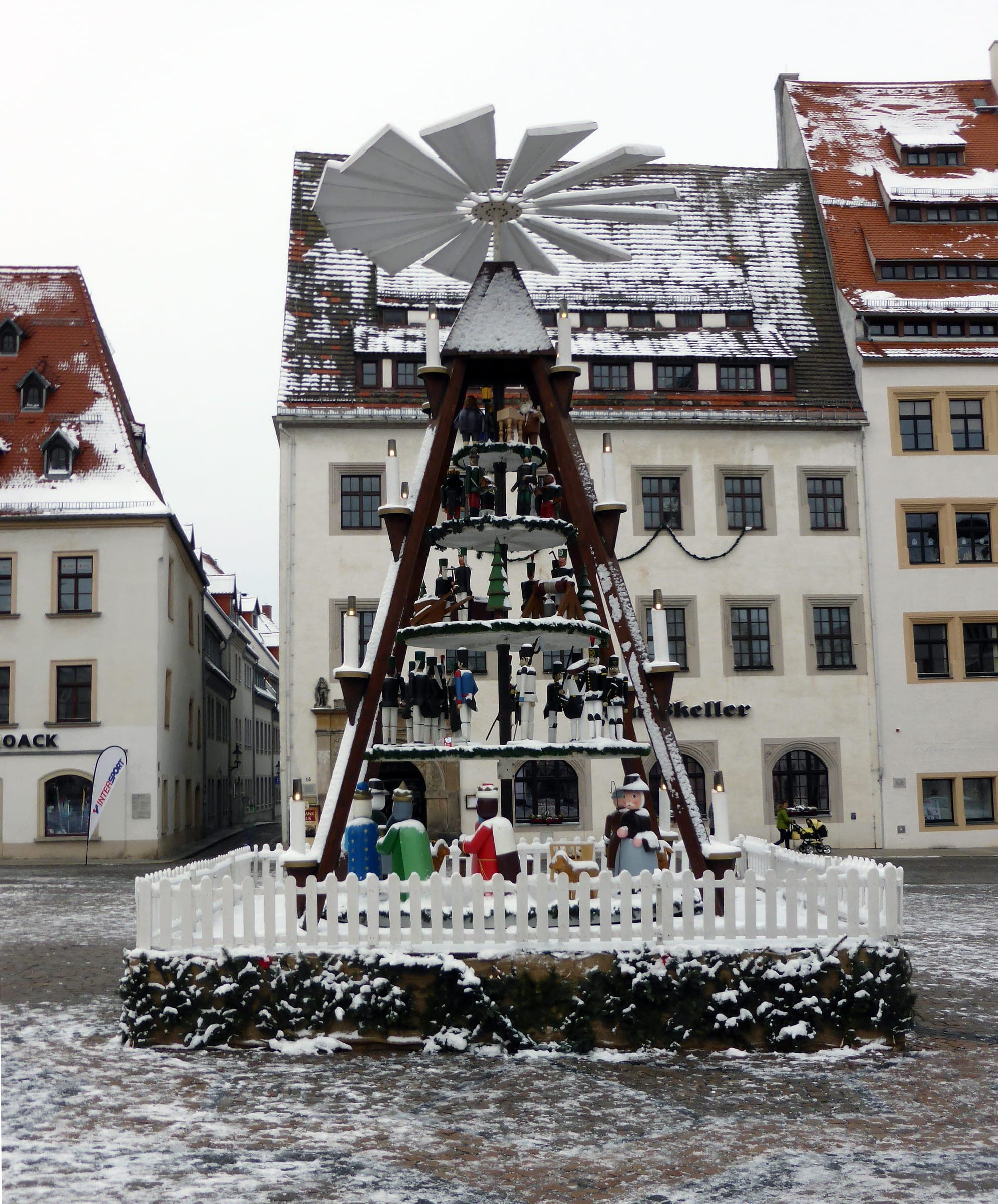Snow dusts the tall Christmas pyramid and the rooftops around the Obermarkt in Freiberg.