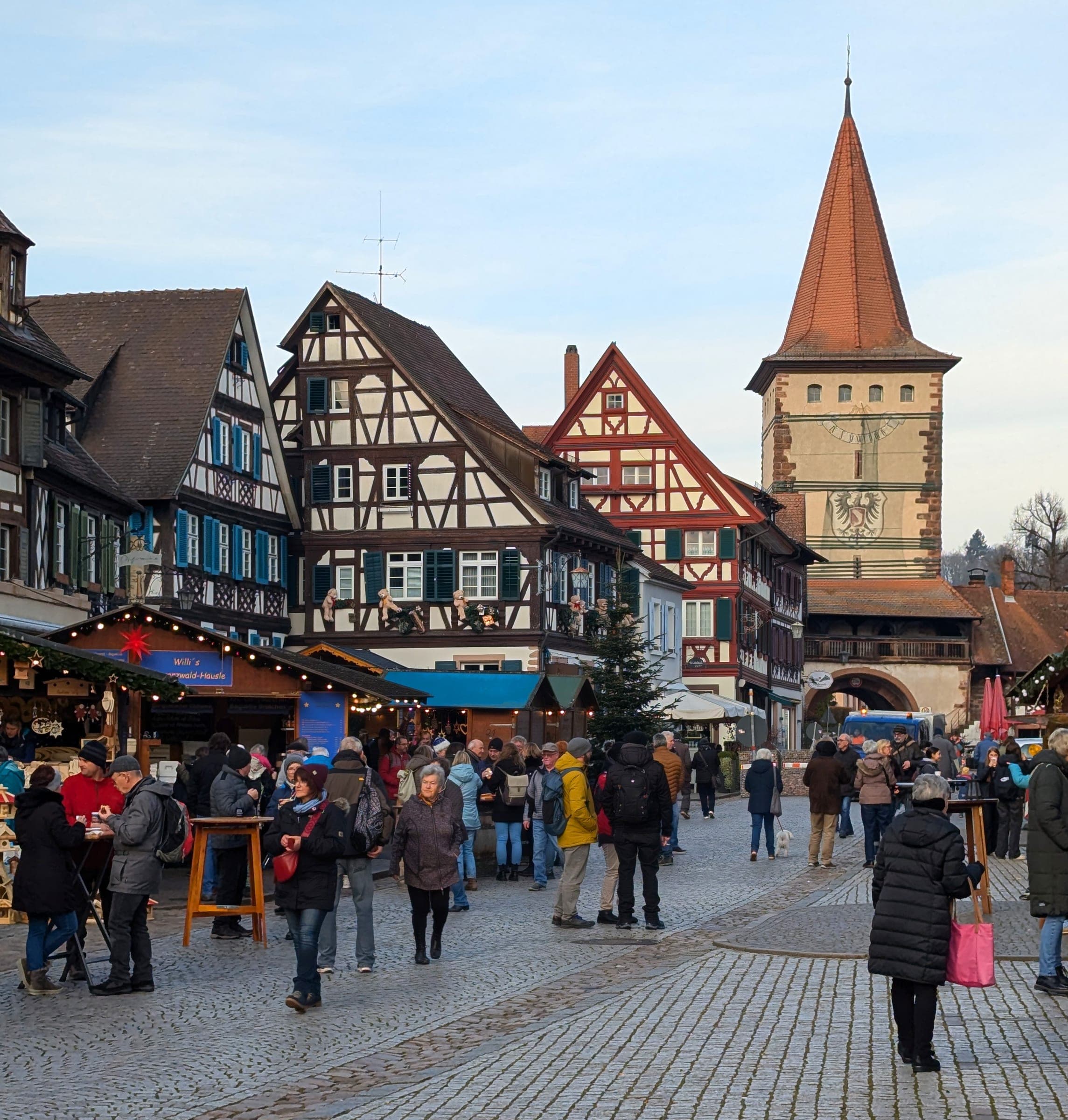Market stalls and timber-framed houses lead to the Obertor tower in Gengenbach during the Adventsmarkt.