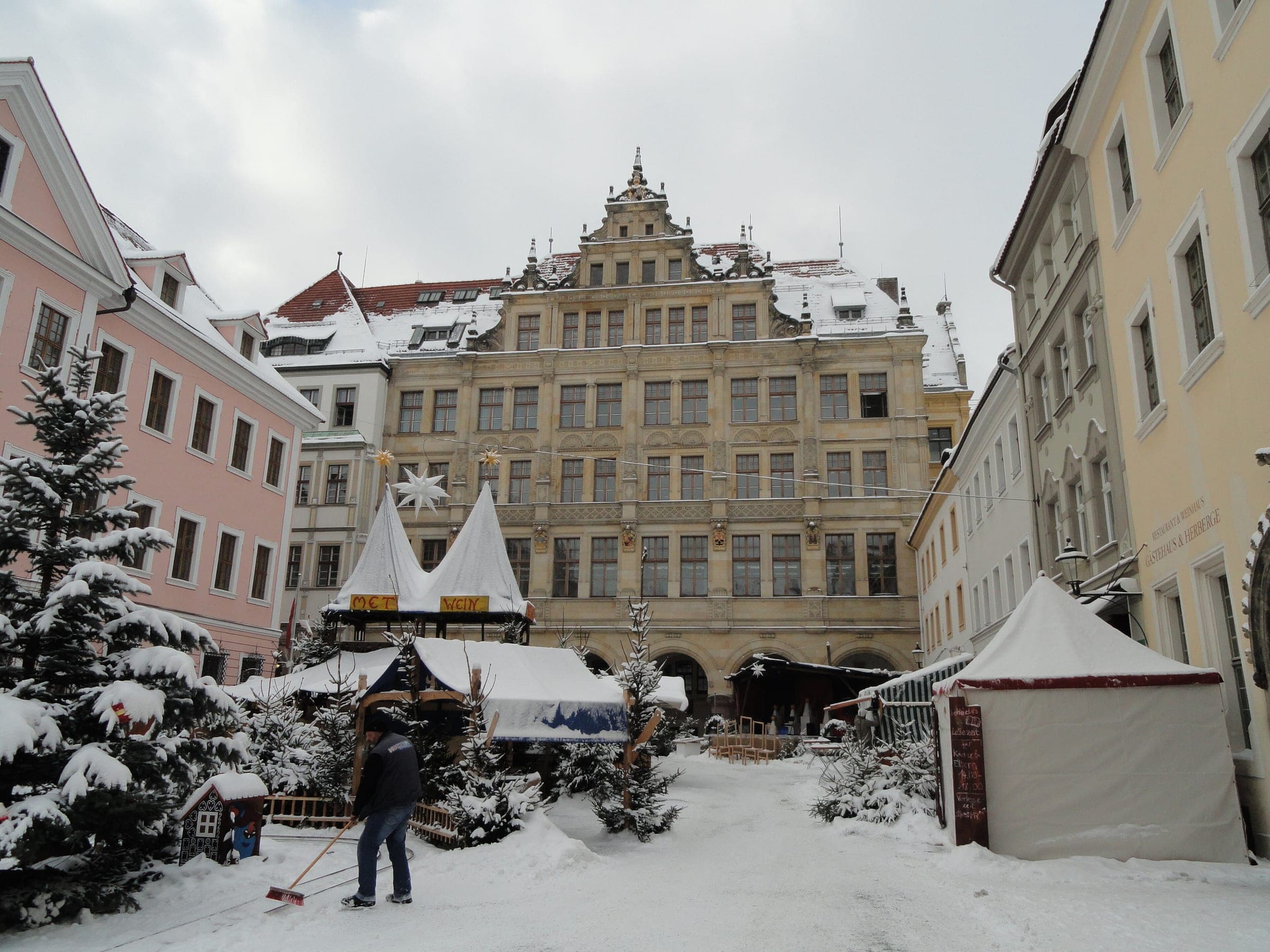 White market tents and snowy trees sit below the gabled Renaissance houses of the Untermarkt in Görlitz.