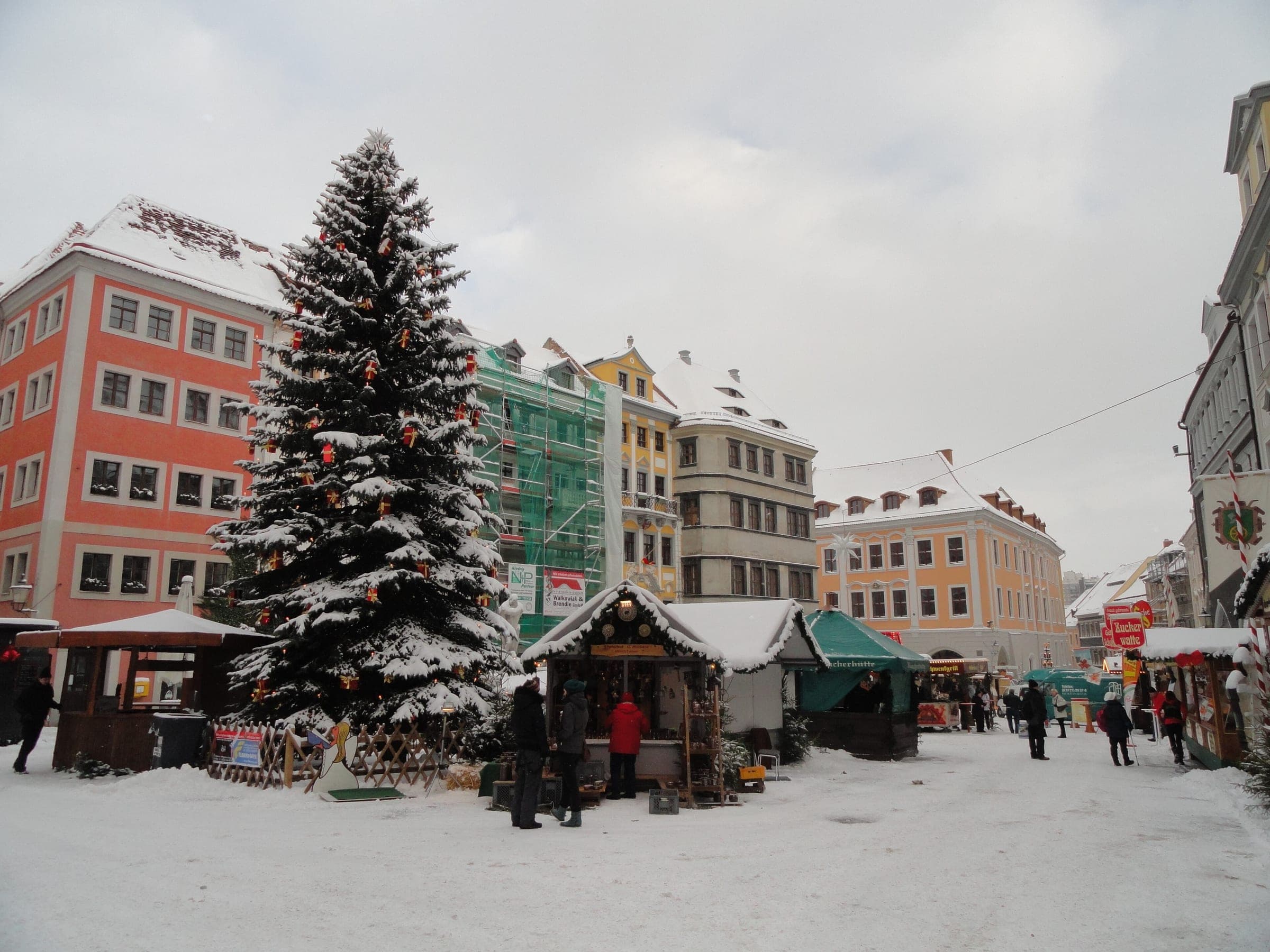 A snow-laden Christmas tree and market stalls stand on the snowy Untermarkt in Görlitz.