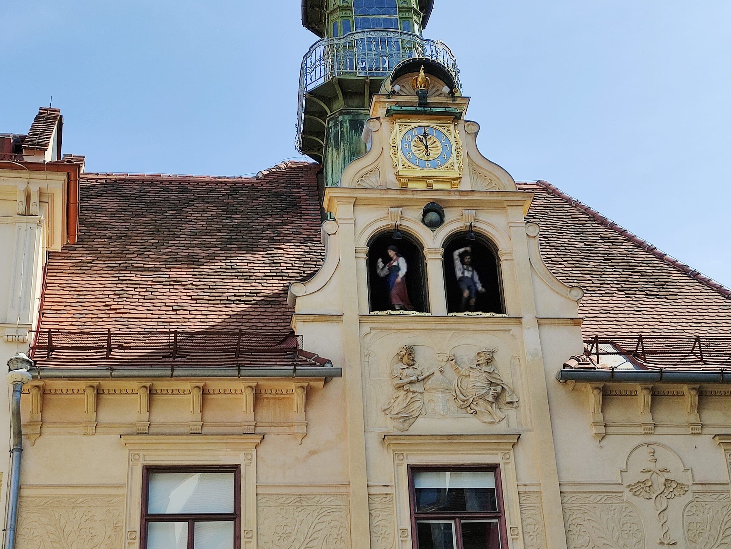 The Glockenspiel house gable with its clock and two dancing-figure windows rises over Glockenspielplatz in Graz.
