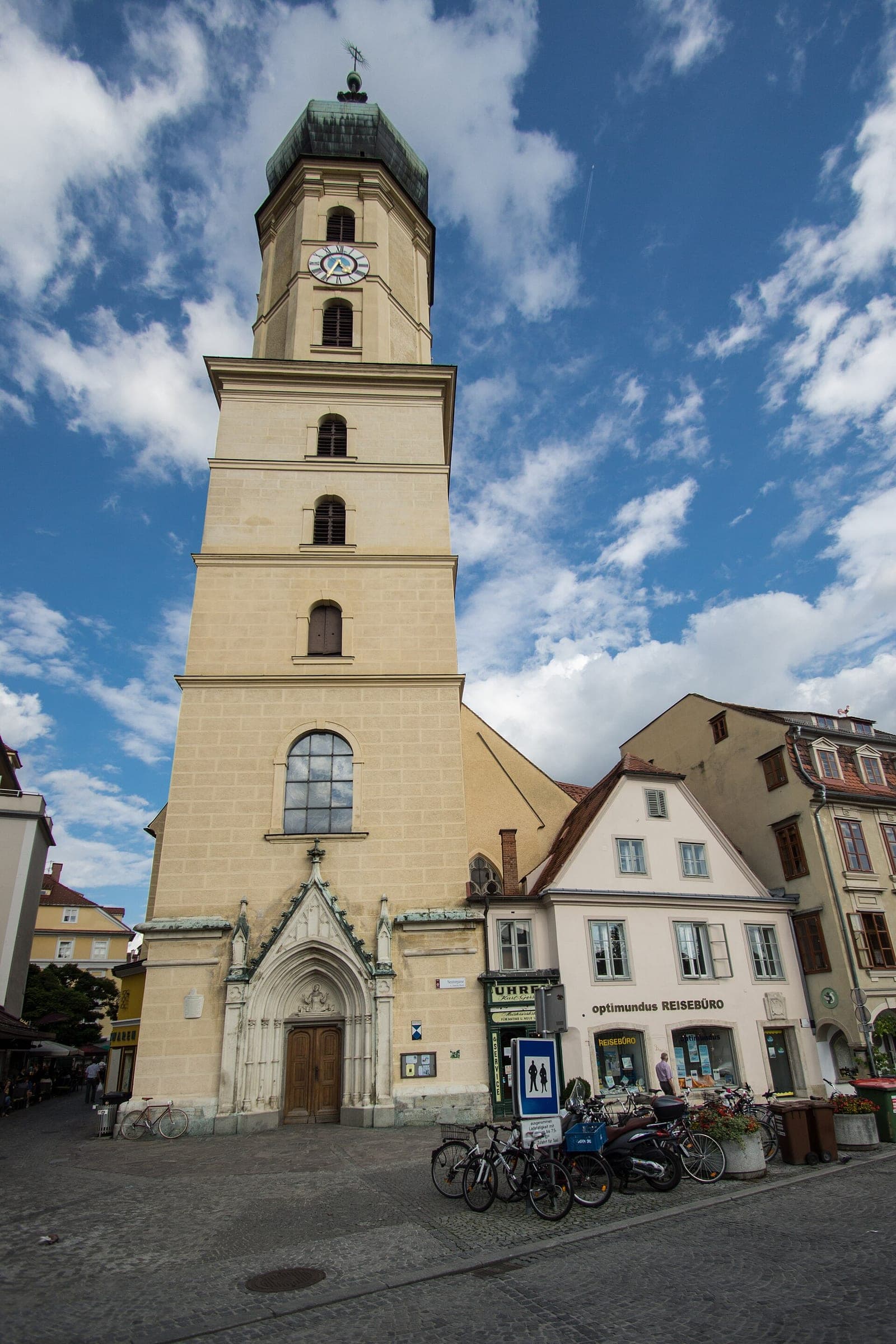 The stone tower of the Franciscan monastery rises over the old-town houses beside Kapistran-Pieller-Platz in Graz.