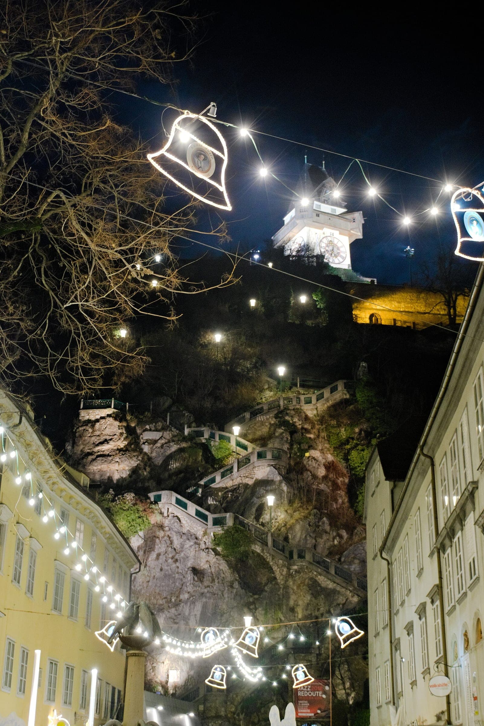 Strings of bell-shaped lights hang over the Kriegssteig stairs as they climb to the Uhrturm on the Graz Schlossberg.