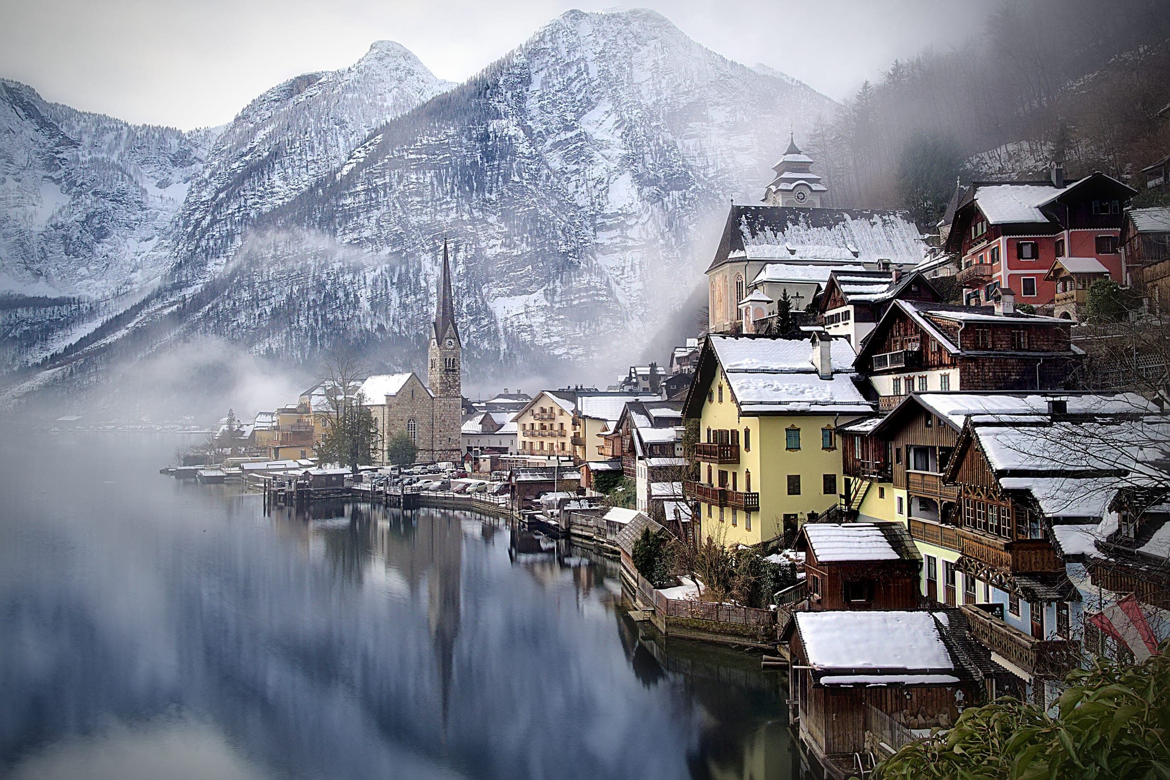 Mist drifts over the Hallstätter See below Hallstatt's snow-covered houses and mountains