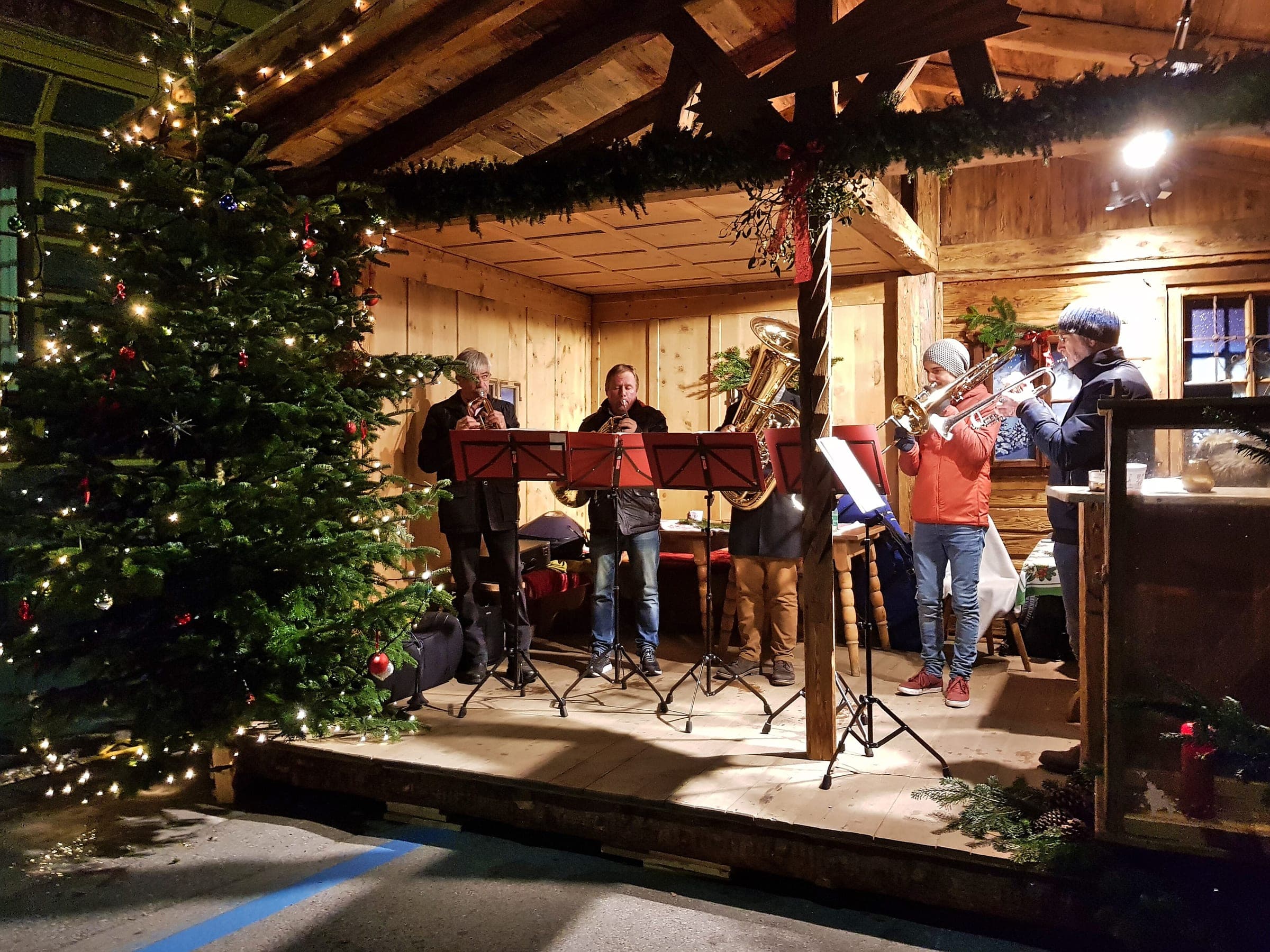 A small brass band plays on the wooden stage of the St. Nikolaus market in Innsbruck.