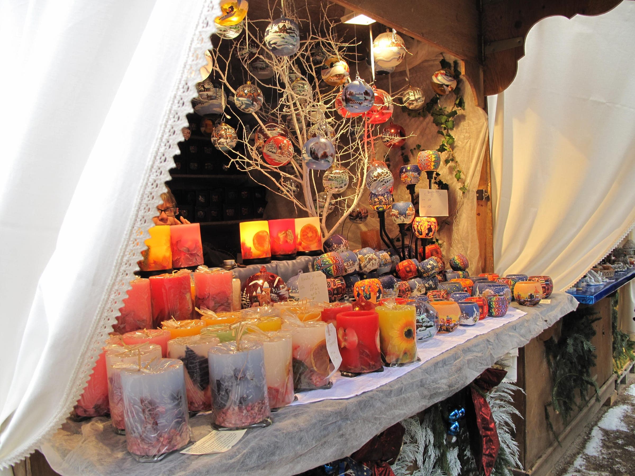 Painted candles and glass baubles fill a lace-trimmed chalet at the Kaysersberg Christmas market.