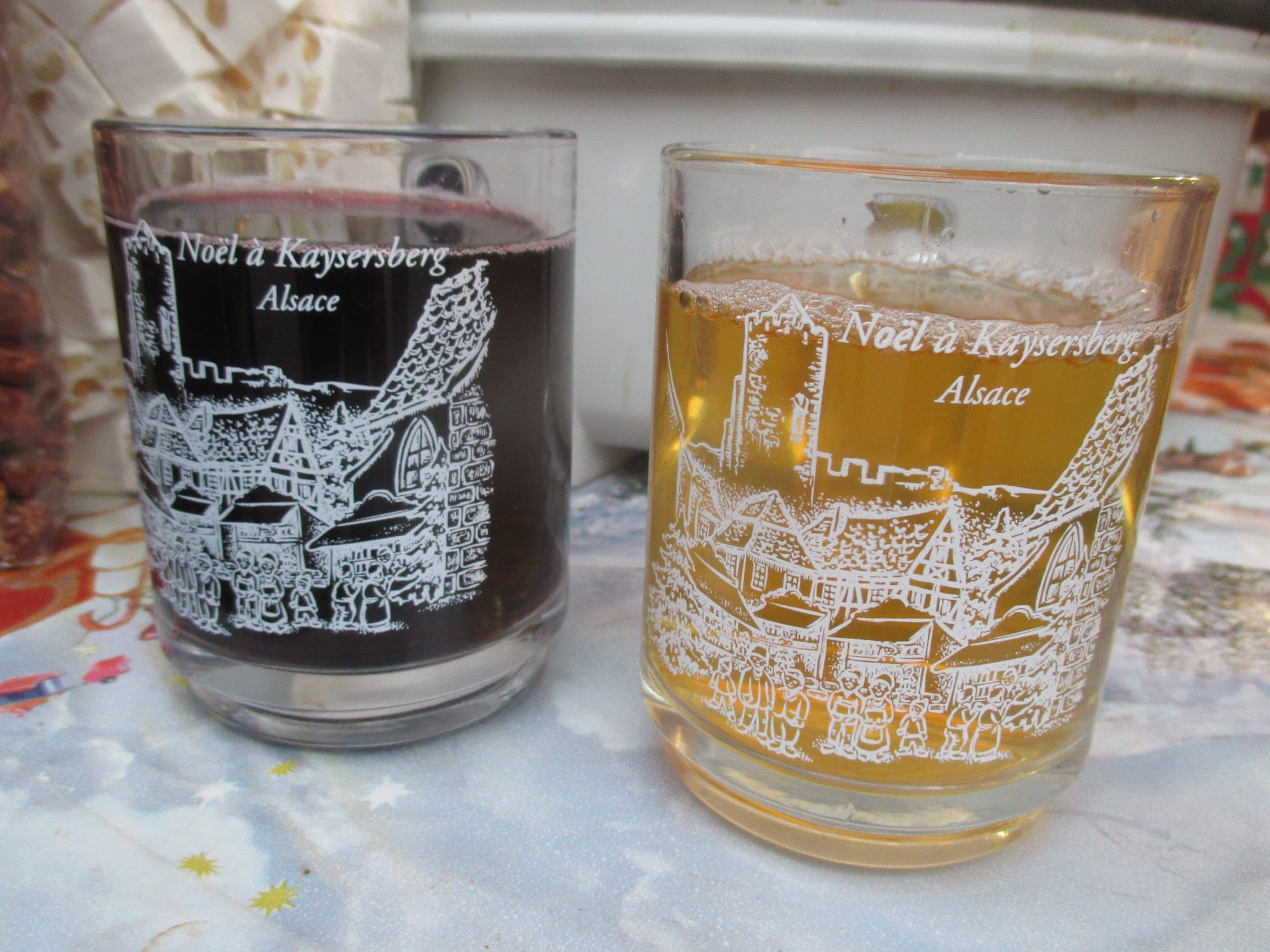 Two glasses of red and white mulled wine carry the printed words Noël à Kaysersberg at the market.