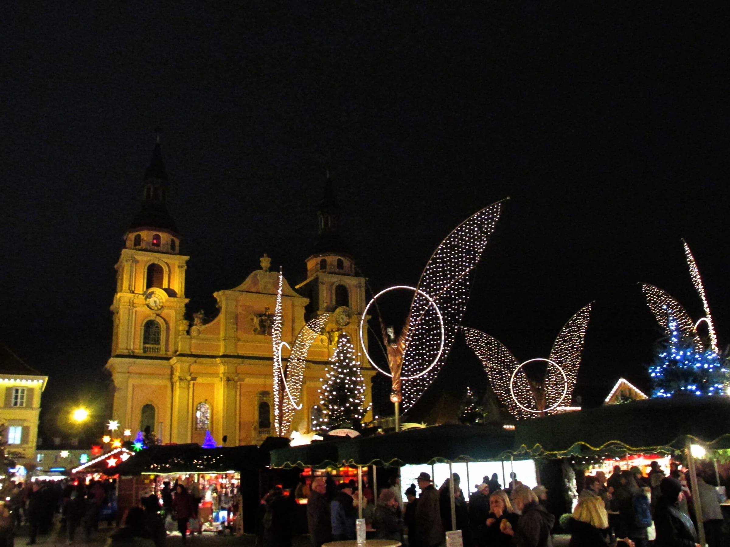 Light angels rise over the stalls on Ludwigsburg's Marktplatz at night in front of the twin-towered Stadtkirche.