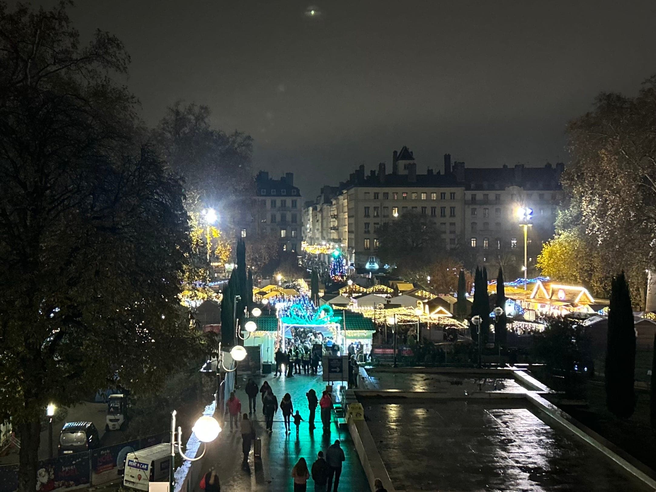 The lit chalets of the Place Carnot Christmas market fill the square in a night view from Perrache in Lyon.