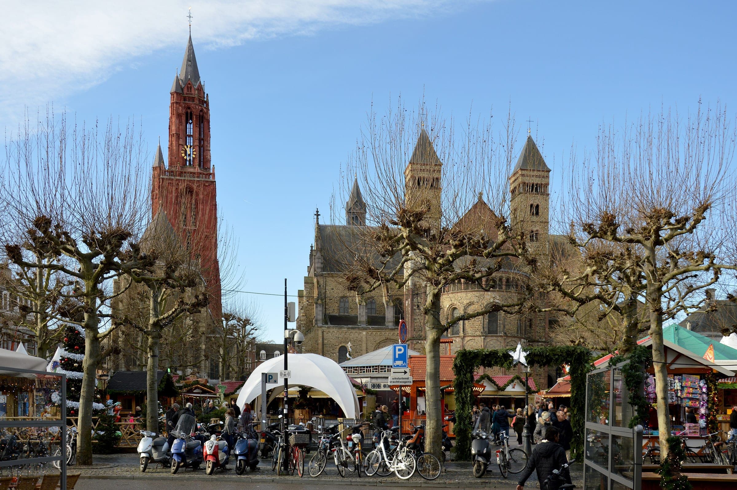 Christmas chalets line the Vrijthof below the red tower of Sint-Janskerk and Saint Servatius in Maastricht.