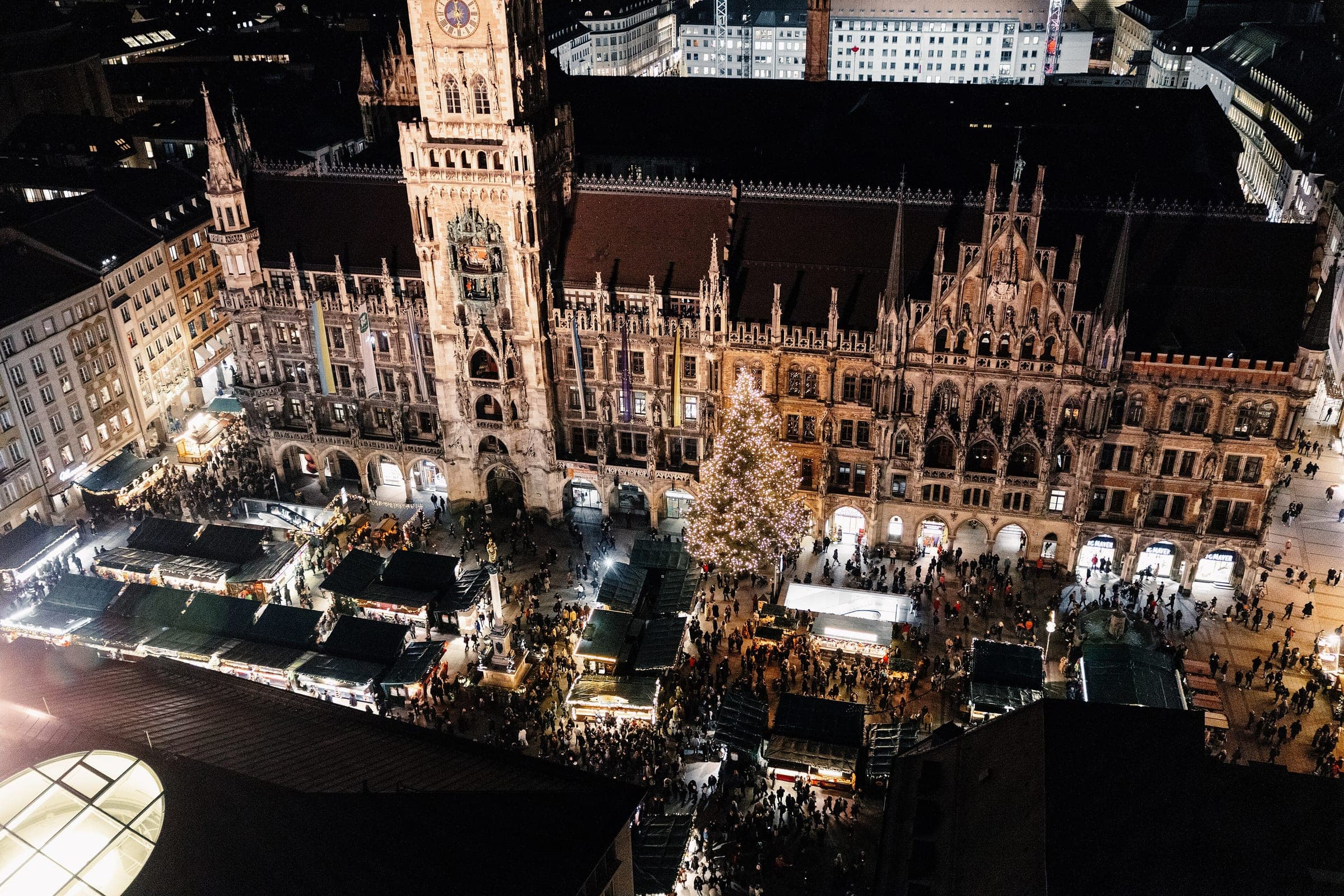 Munich's Christkindlmarkt glows at night below the Neues Rathaus on Marienplatz, seen from the tower of St. Peter.