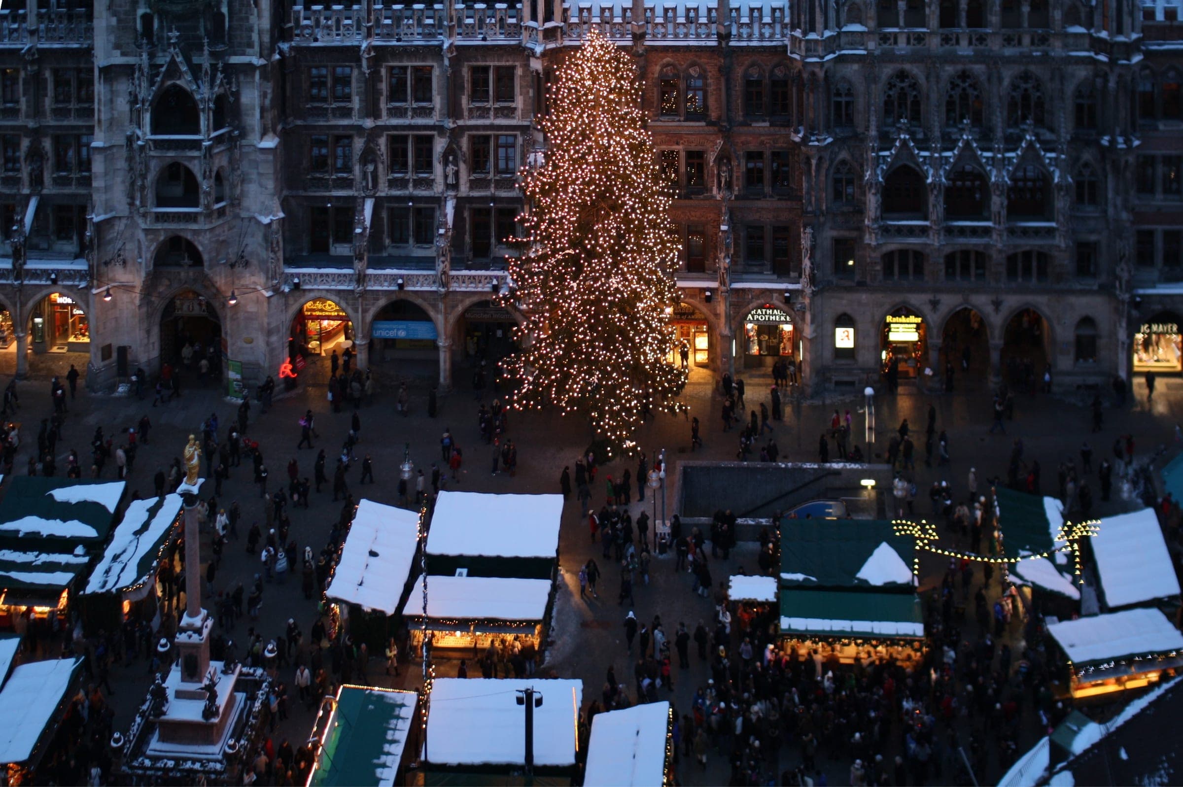 The big lit Christmas tree stands in front of the Neues Rathaus as dusk falls over the Marienplatz stalls.