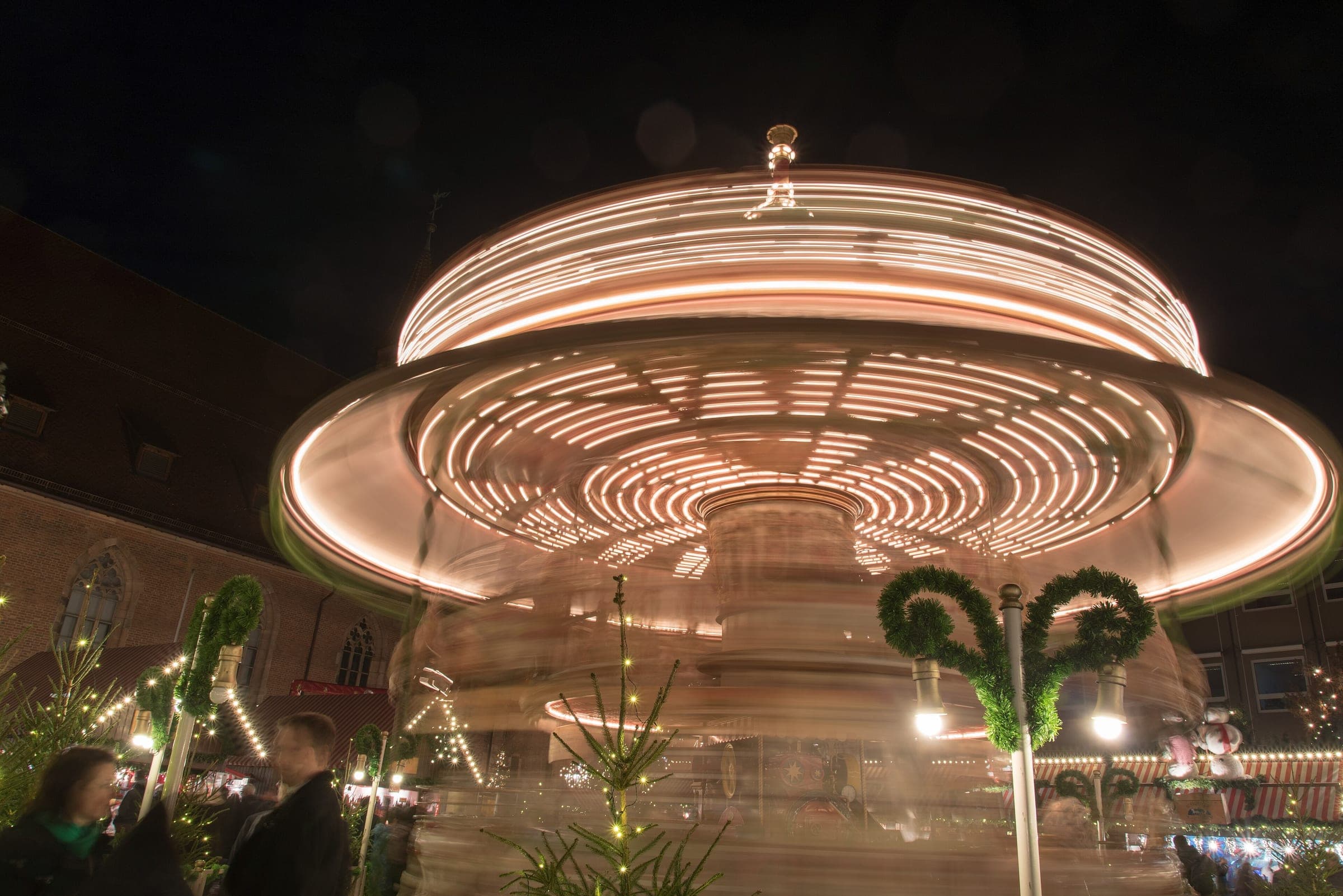 A long exposure turns the carousel at Nuremberg's Kinderweihnacht into rings of light on a December night