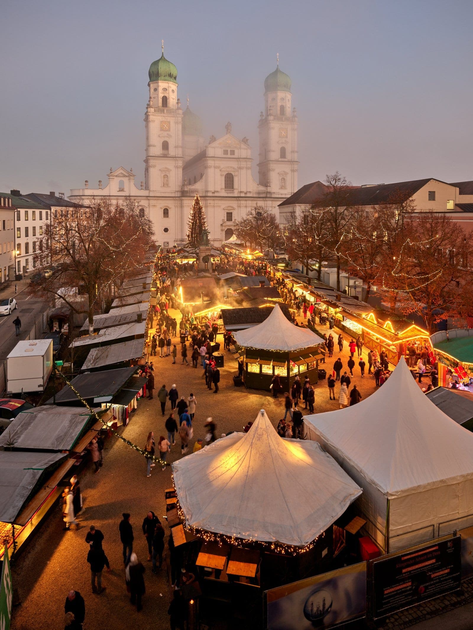 Seen from above at dusk, the Passau Christmas market stretches across Domplatz toward St. Stephen's Cathedral.