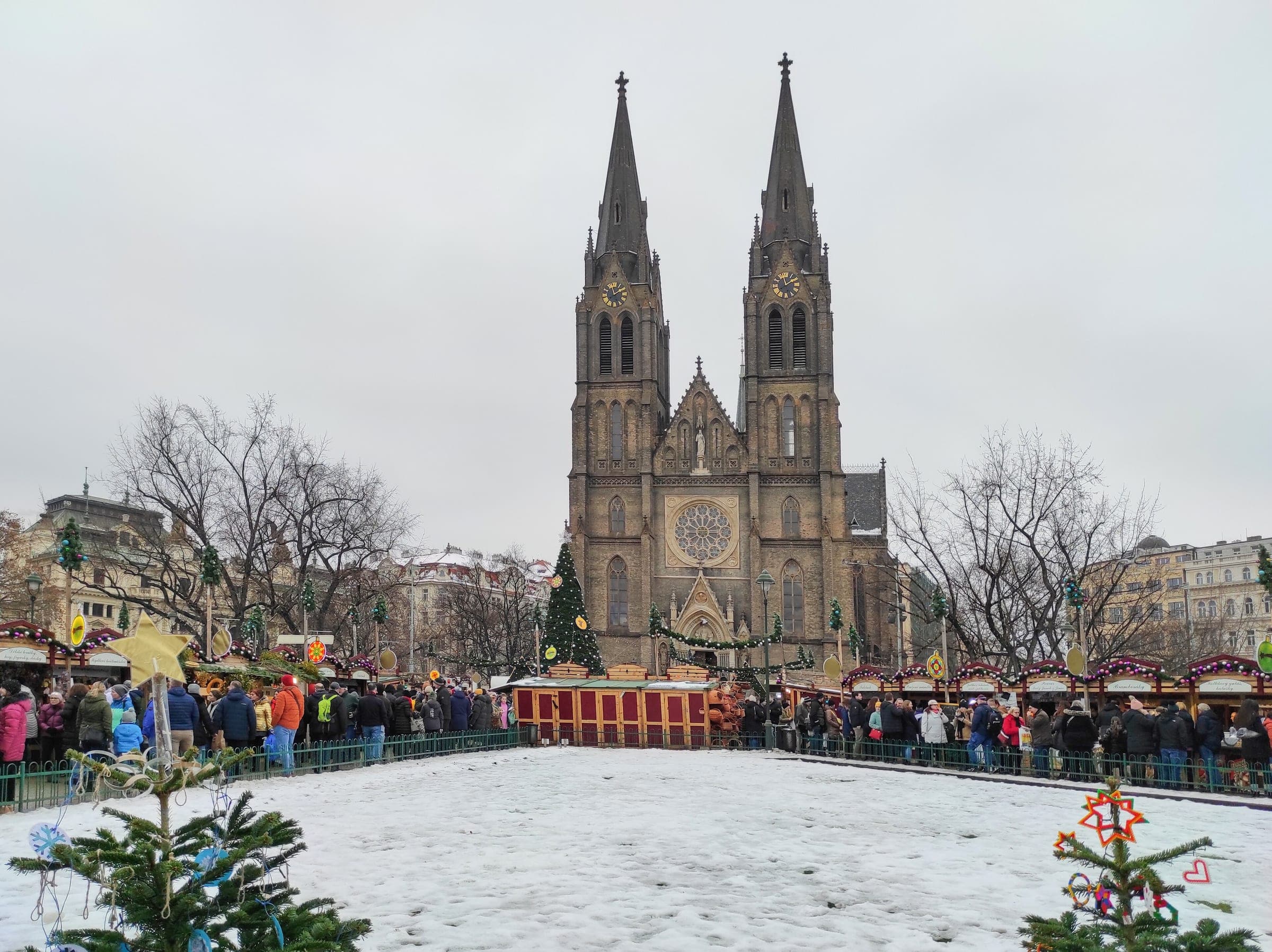 Snow covers náměstí Míru in Prague as Christmas stalls ring the square below the Church of St Ludmila.