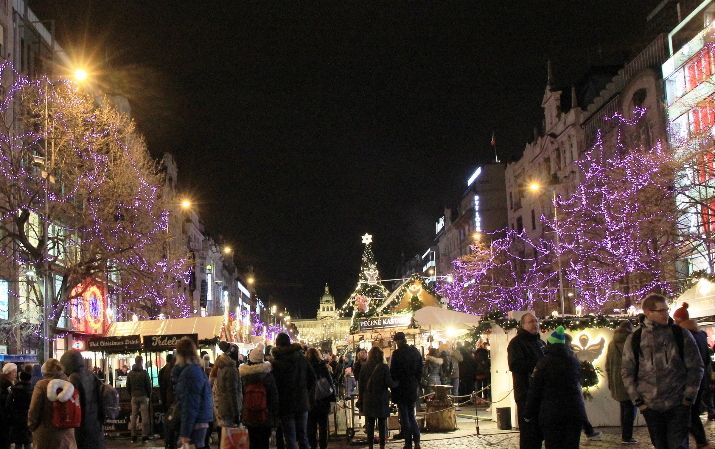 Purple lights hang in the trees over the Wenceslas Square market as the street climbs to the National Museum.