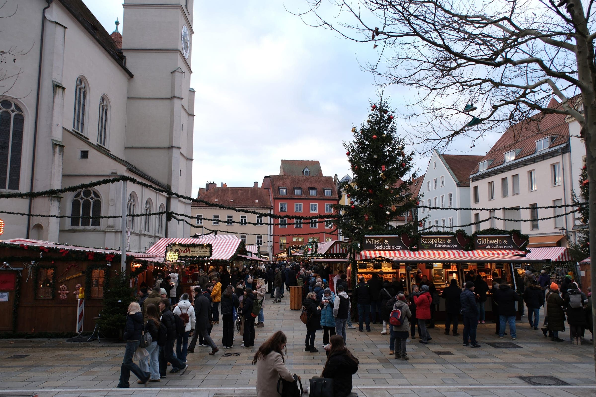 Stalls and a tall Christmas tree fill Neupfarrplatz in Regensburg beside the Neupfarrkirche.