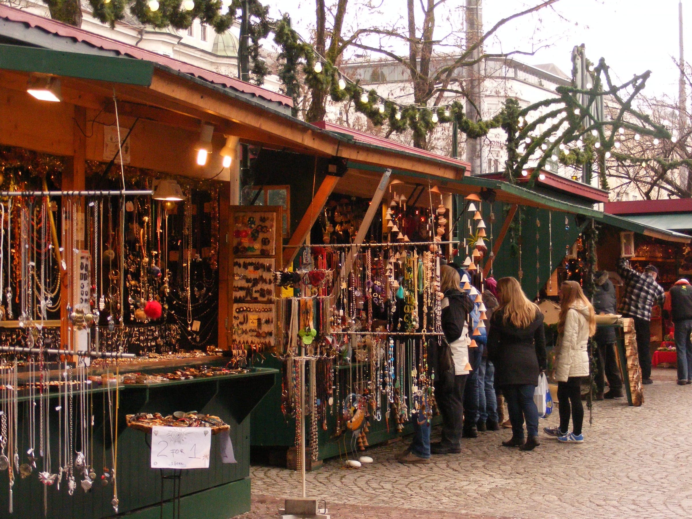 Shoppers browse jewellery stalls under pine garlands at the Mirabellplatz market in Salzburg