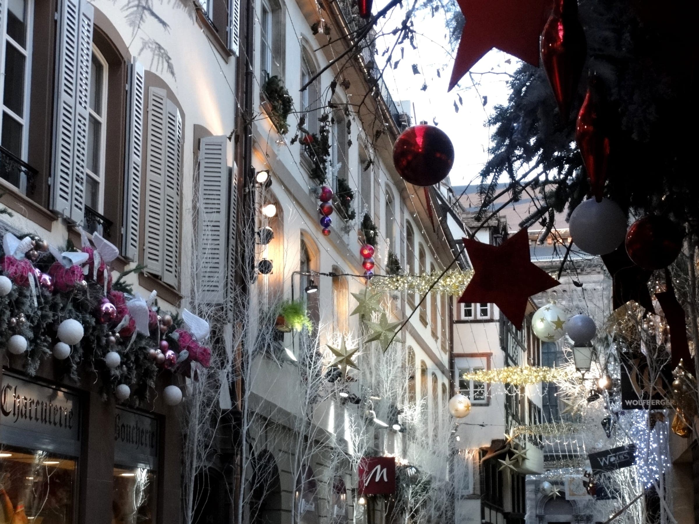 Red baubles and stars hang above the shuttered facades of a Carré d'Or street in Strasbourg.