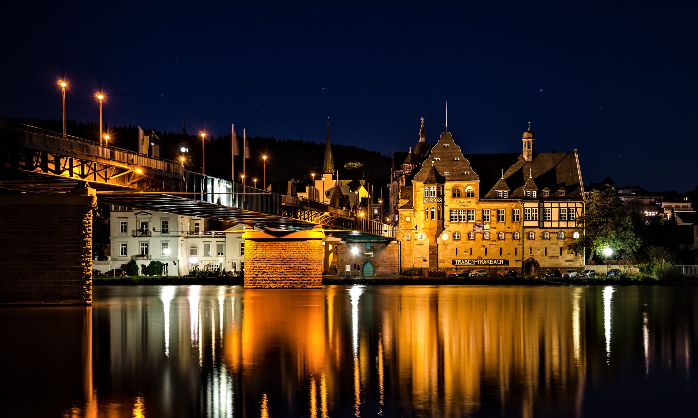 The old post office and the Moselle bridge in Traben-Trarbach reflect in the river at night
