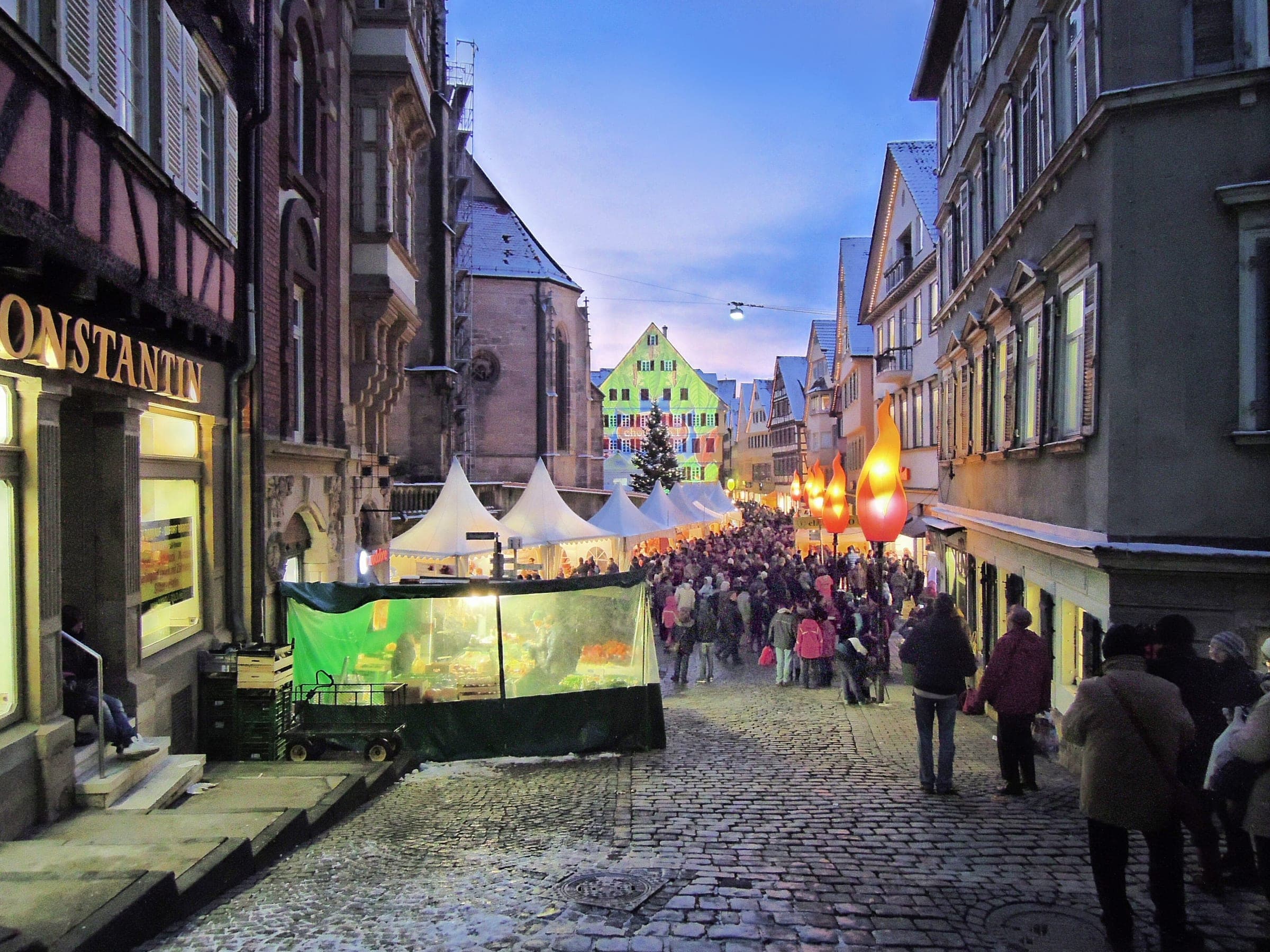 Visitors stream down a cobbled lane of Tübingen's old town toward the chocolART tents at dusk.