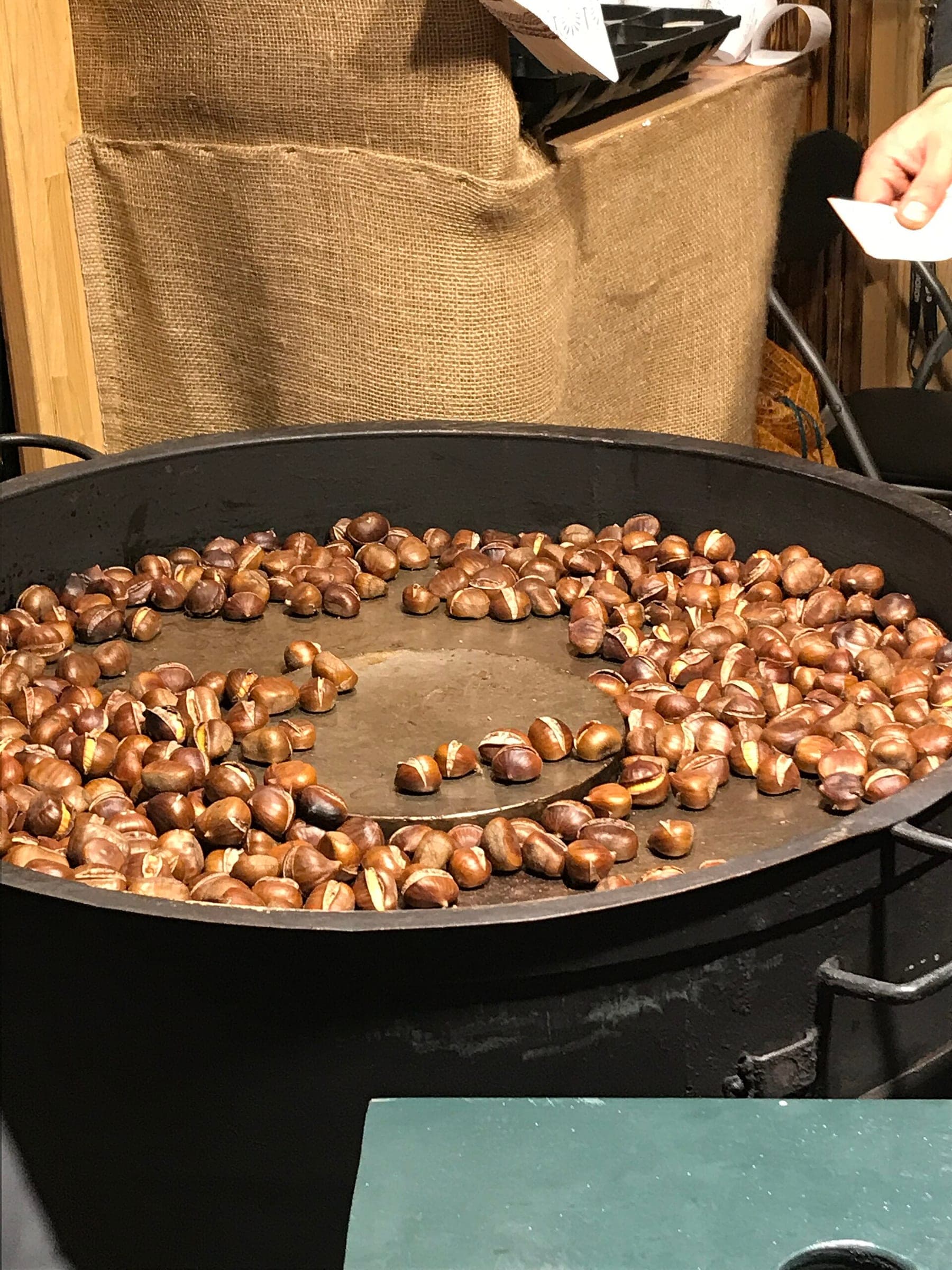Chestnuts roast in a wide iron pan at the Schonbrunn Christmas market in Vienna.