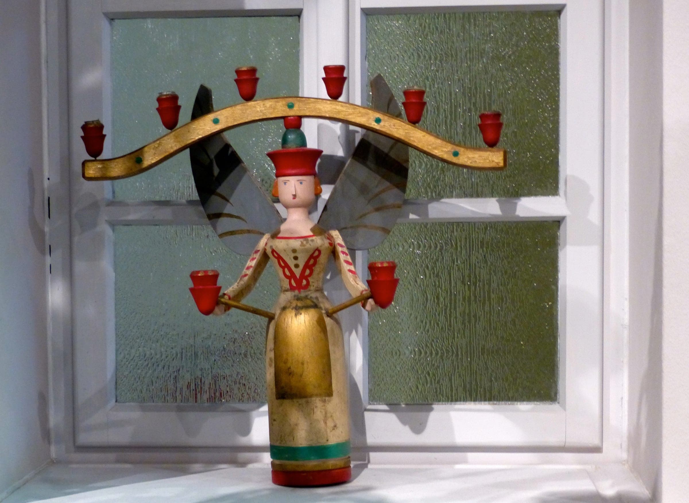 A painted wooden light angel from around 1900 holds red candle cups in the Erzgebirge Toy Museum in Seiffen.