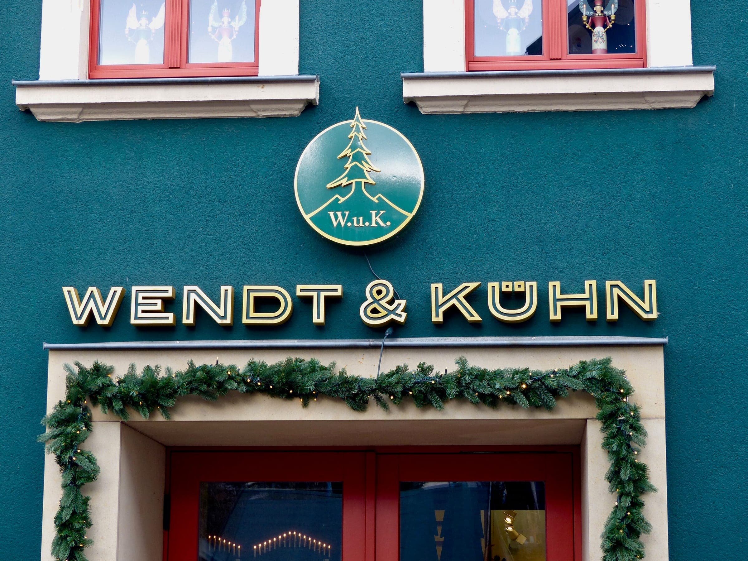 A green garland hangs over the door of the Wendt & Kühn store on the main street of Seiffen in December.
