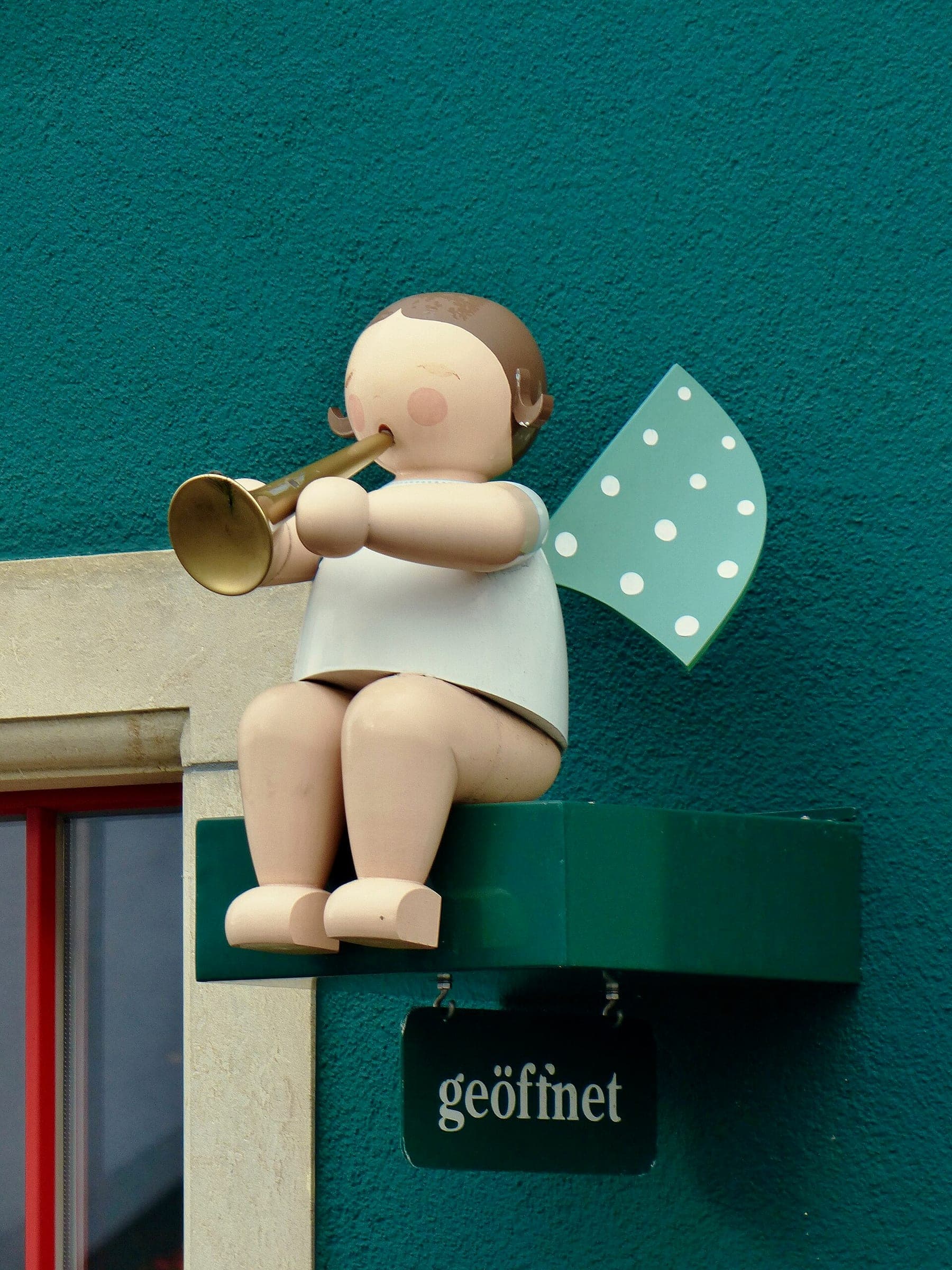 A large wooden angel with a trumpet sits on a bracket over the door of the Wendt & Kühn store in Seiffen.