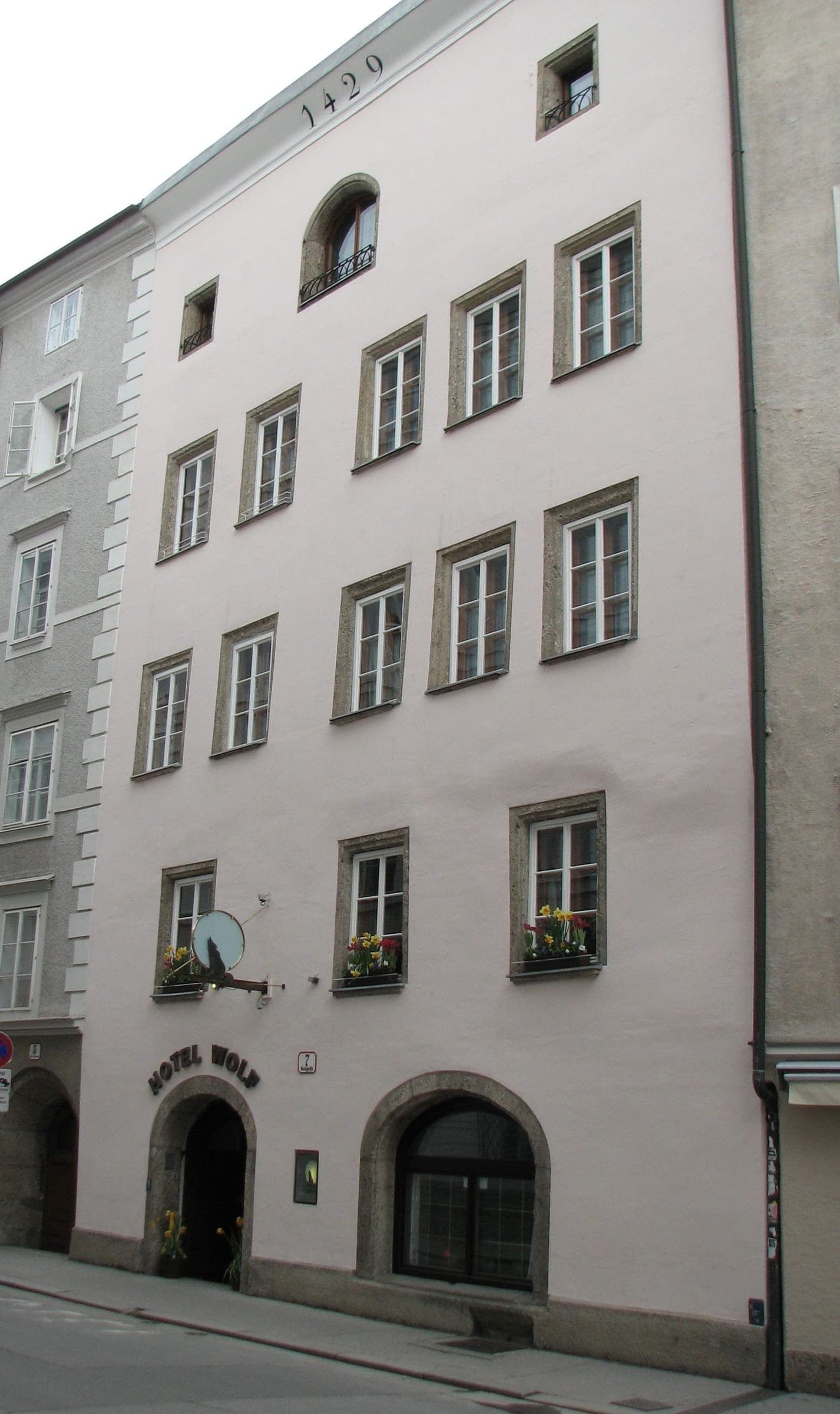 The 1429 date crowns the pale façade of Altstadthotel Wolf at Kaigasse 7 in Salzburg's old town