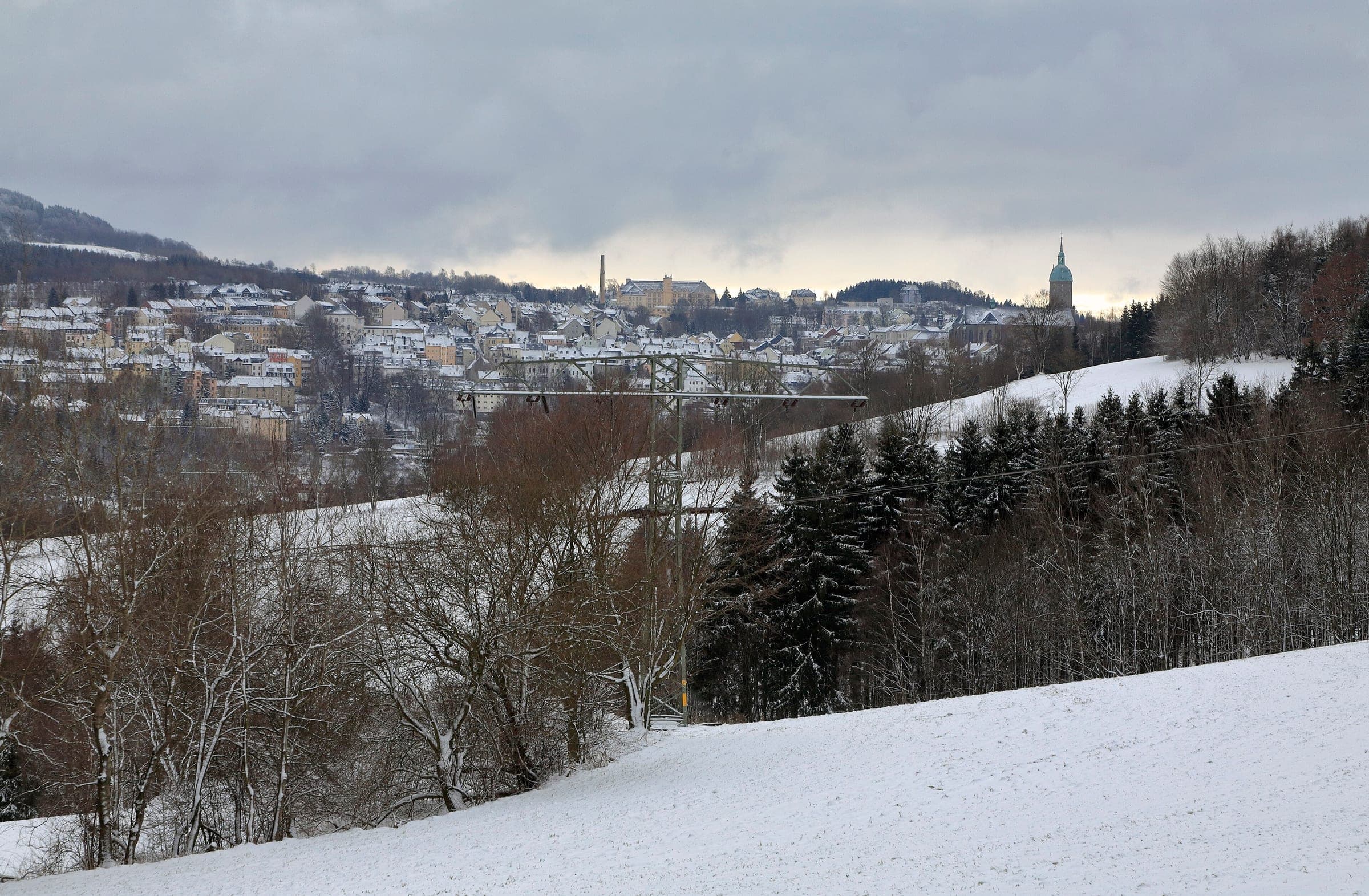 Annaberg-Buchholz spreads across a snowy hillside in the Ore Mountains on a grey winter day.
