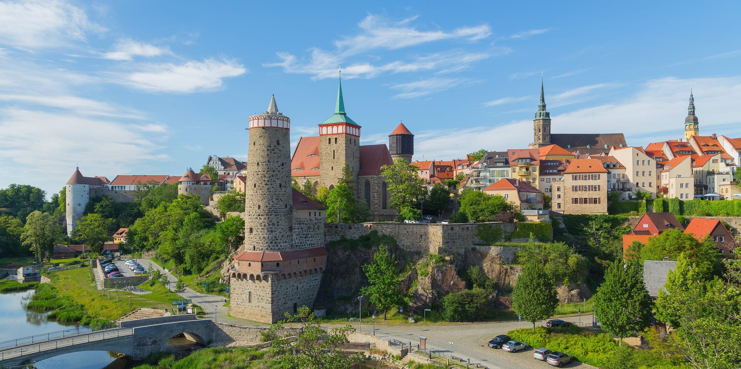 Bautzen's towers and old town walls rise above the Spree valley on a clear summer day.