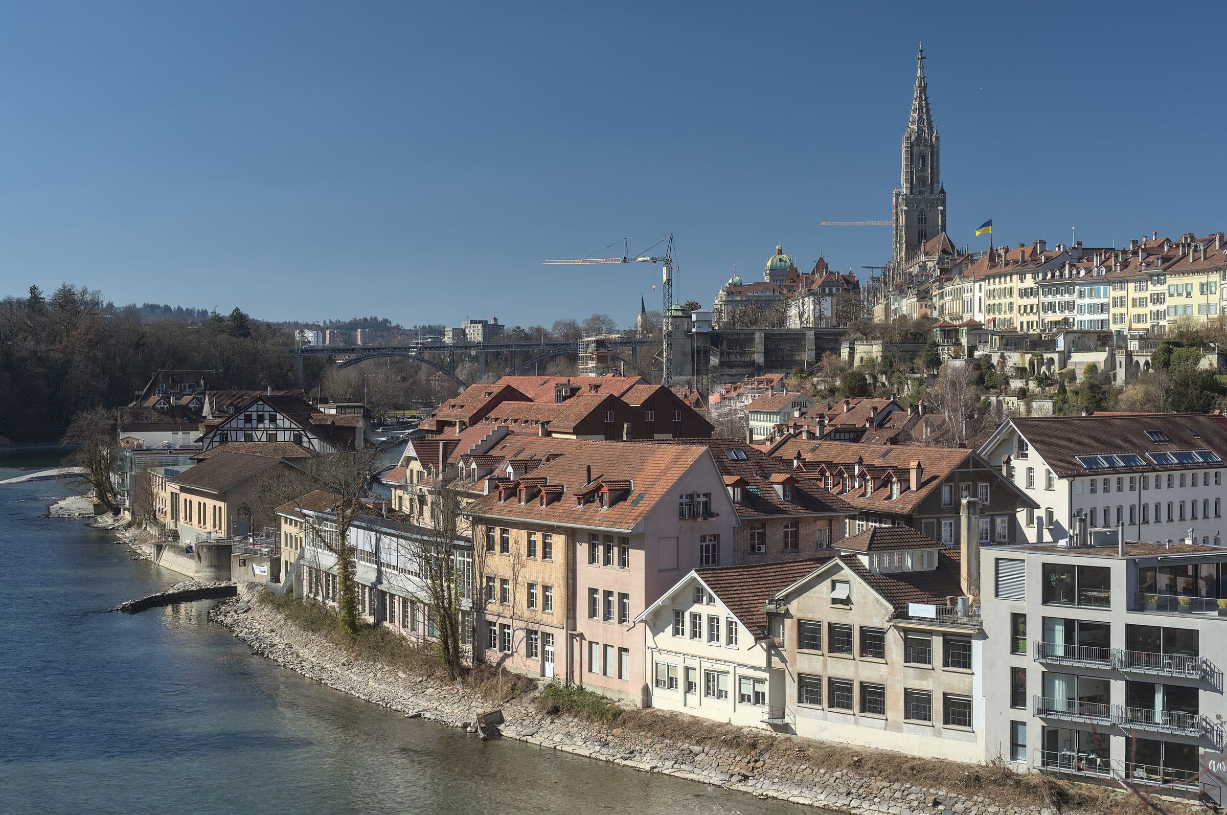 Houses of the Matte quarter line the Aare in Bern beneath the old town and the Minster in February